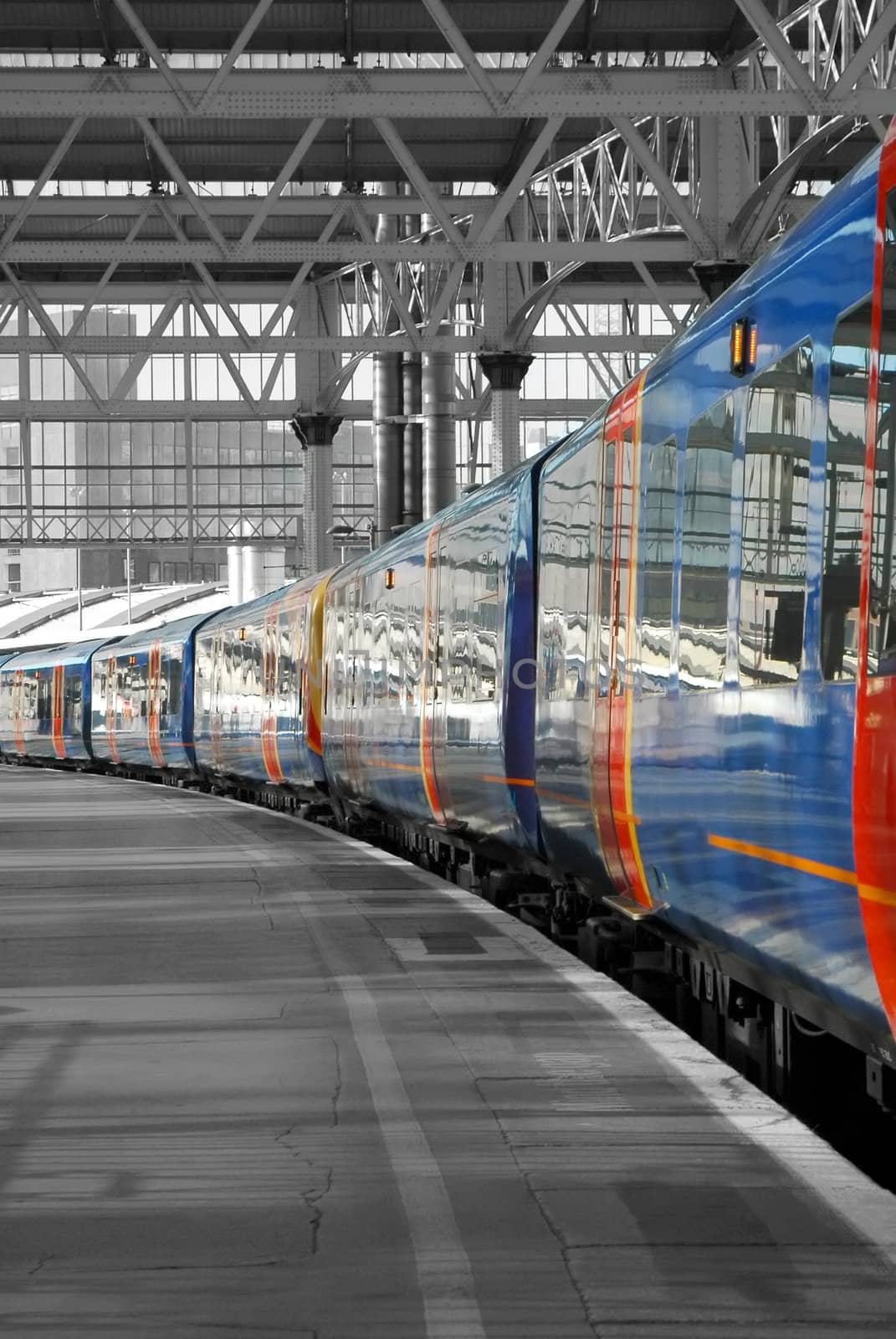 commuter train leaving an empty station platform