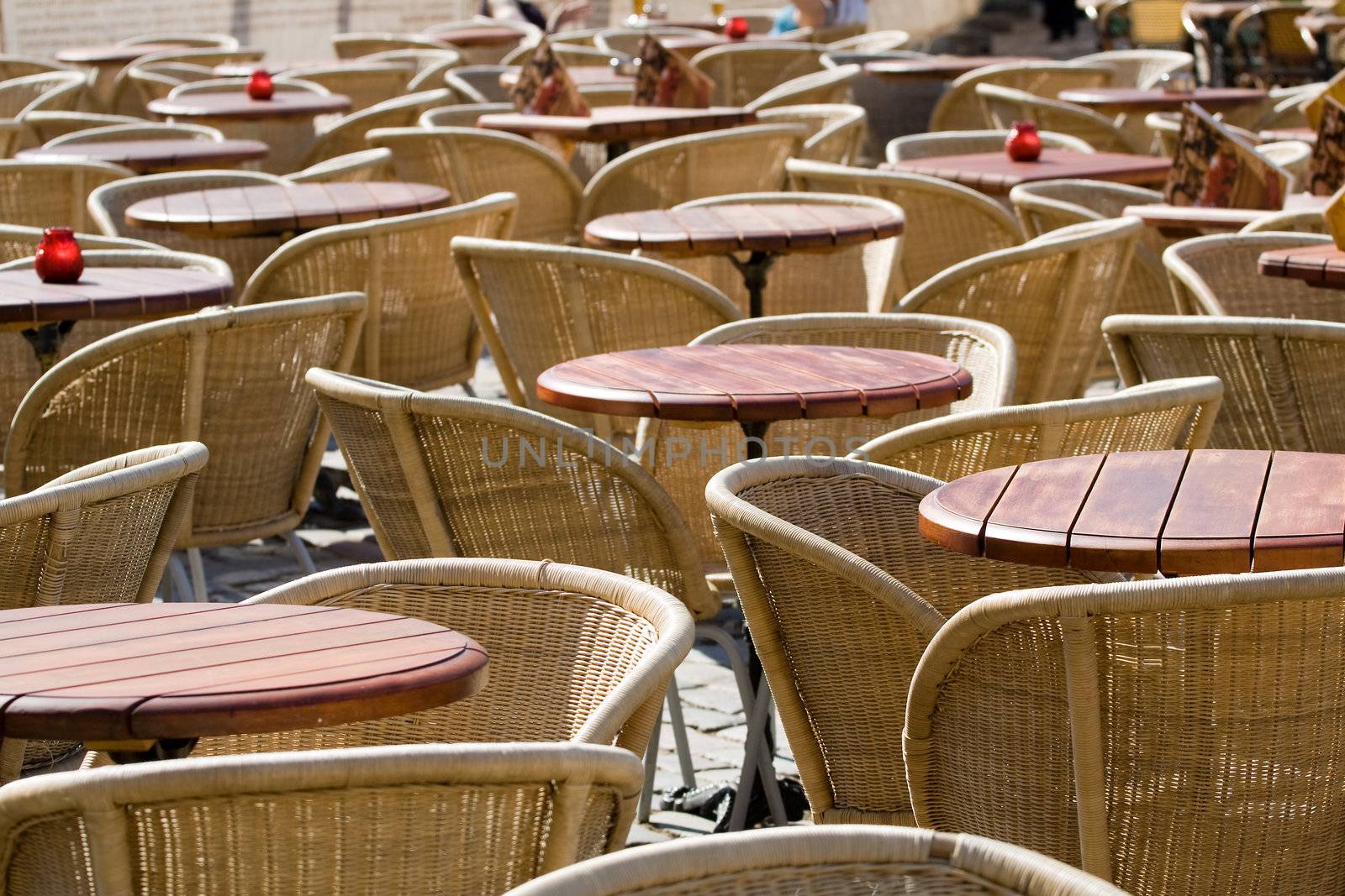 Many empty chairs and tables in outside cafe