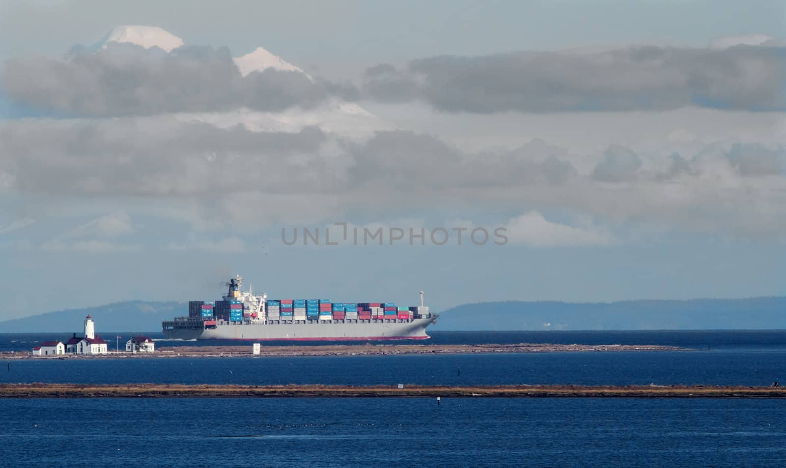 Fully loaded frieghter passing a light house on a Juan de Fuca spit