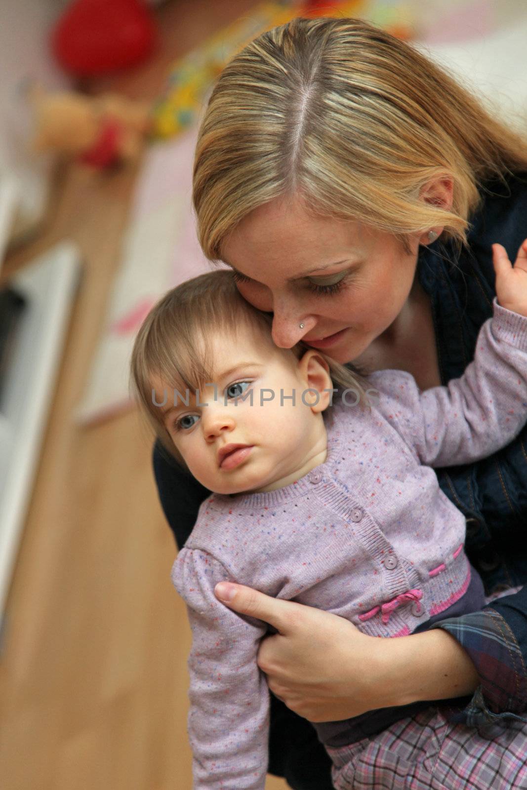 Young, blonde mother hugged her little loving baby.
