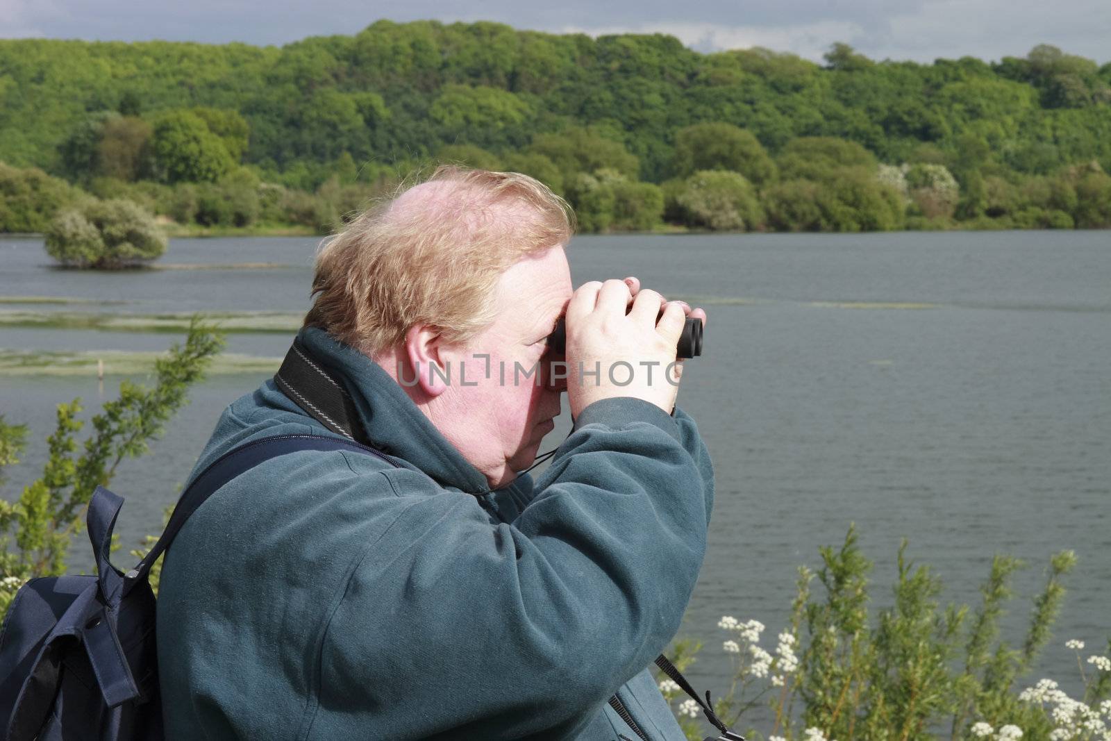 man with his binoculars looking out for birds 
