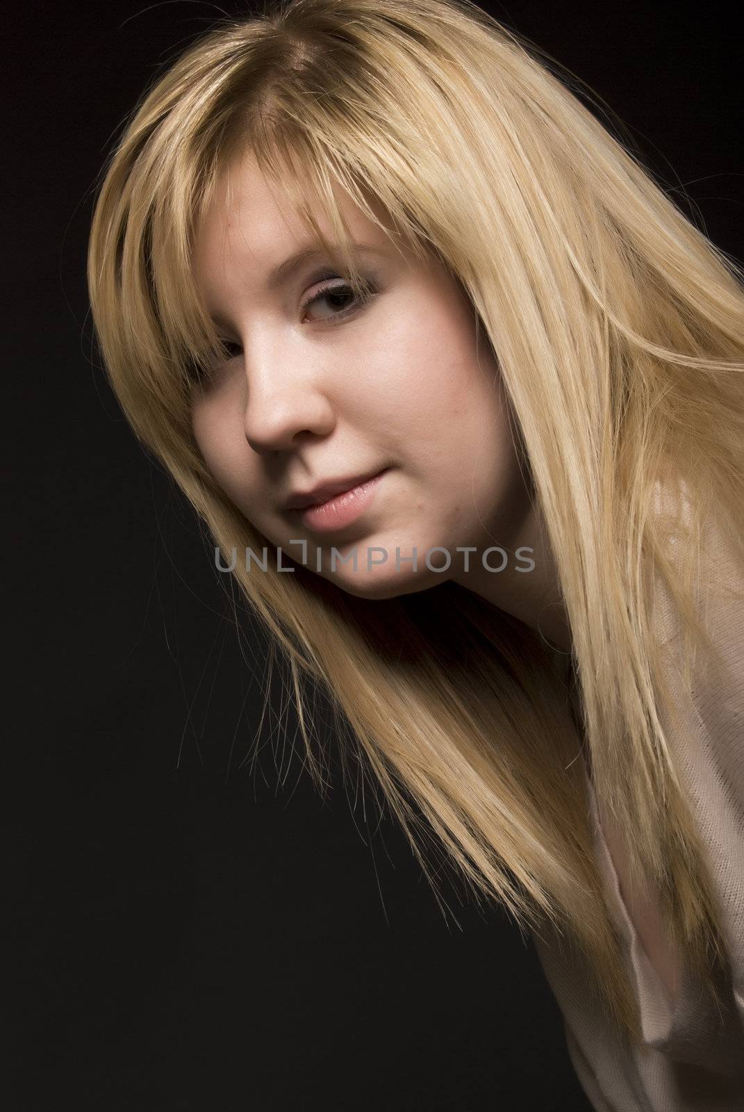 Portrait of a young seductive blonde over black