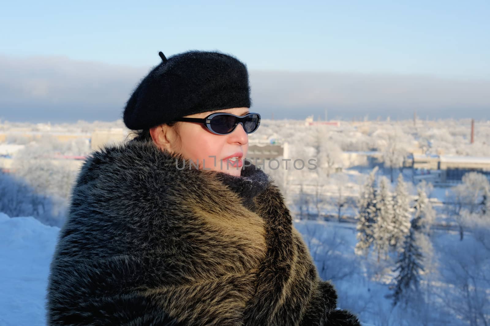Woman in fur coat against the background of winter cityscape