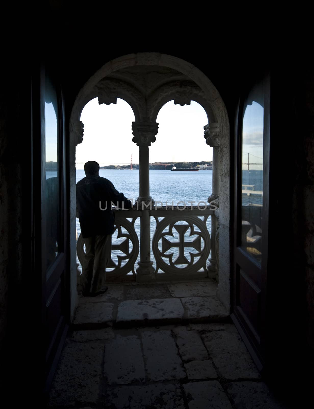 man looking out over the ocean from a balcony of the Torre de Belem