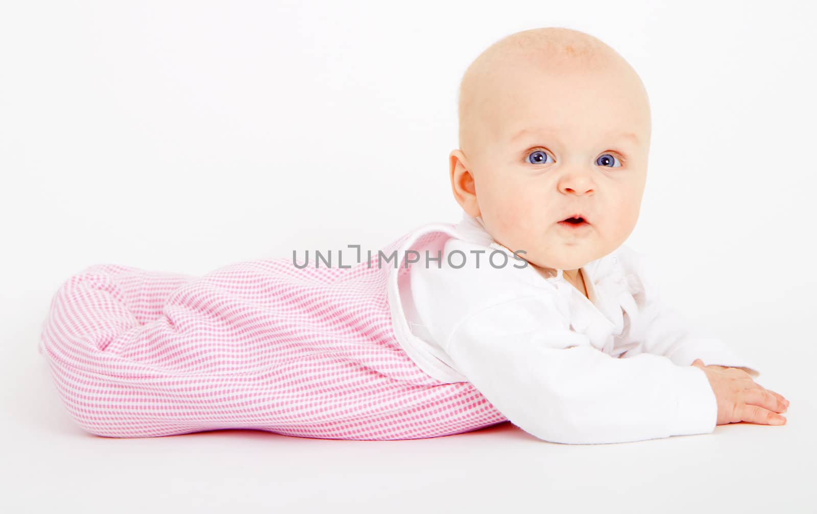 infant girl lying on a white background
