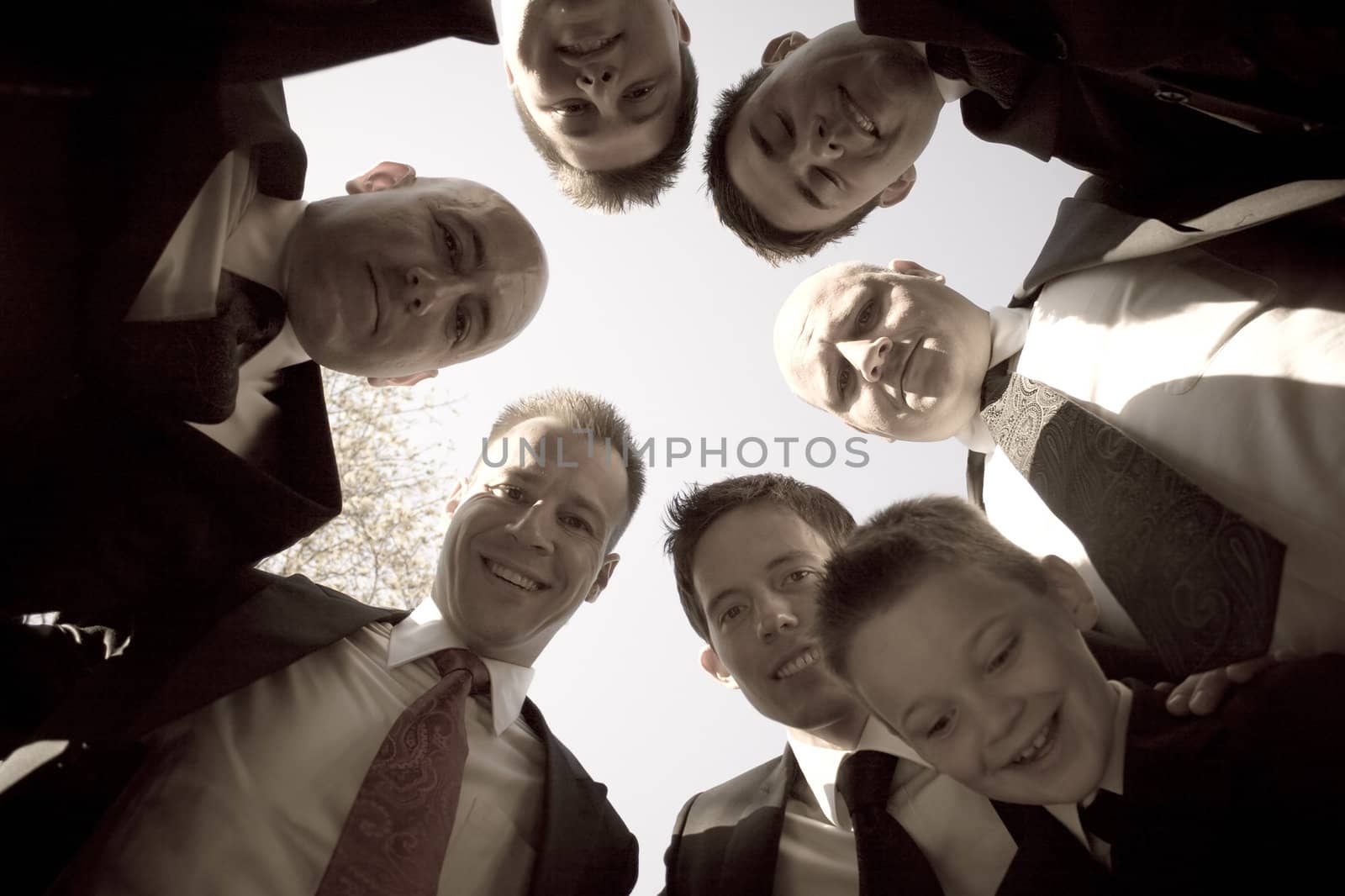 A groom and his groomsmen posing together in a huddle formation.