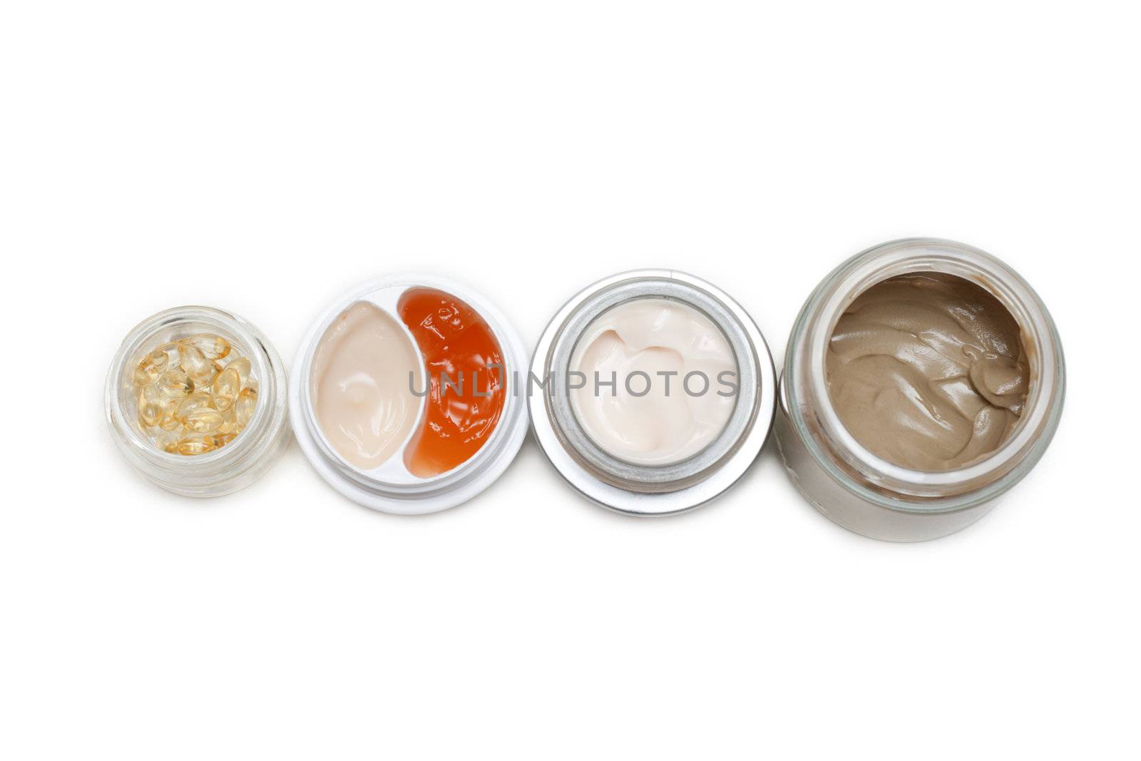 Opened banks with make-up cream on white background
