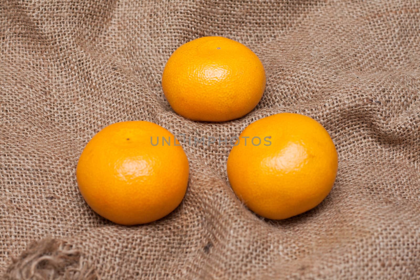 Three tangerines on sackcloth with limited by depth to sharpnesses