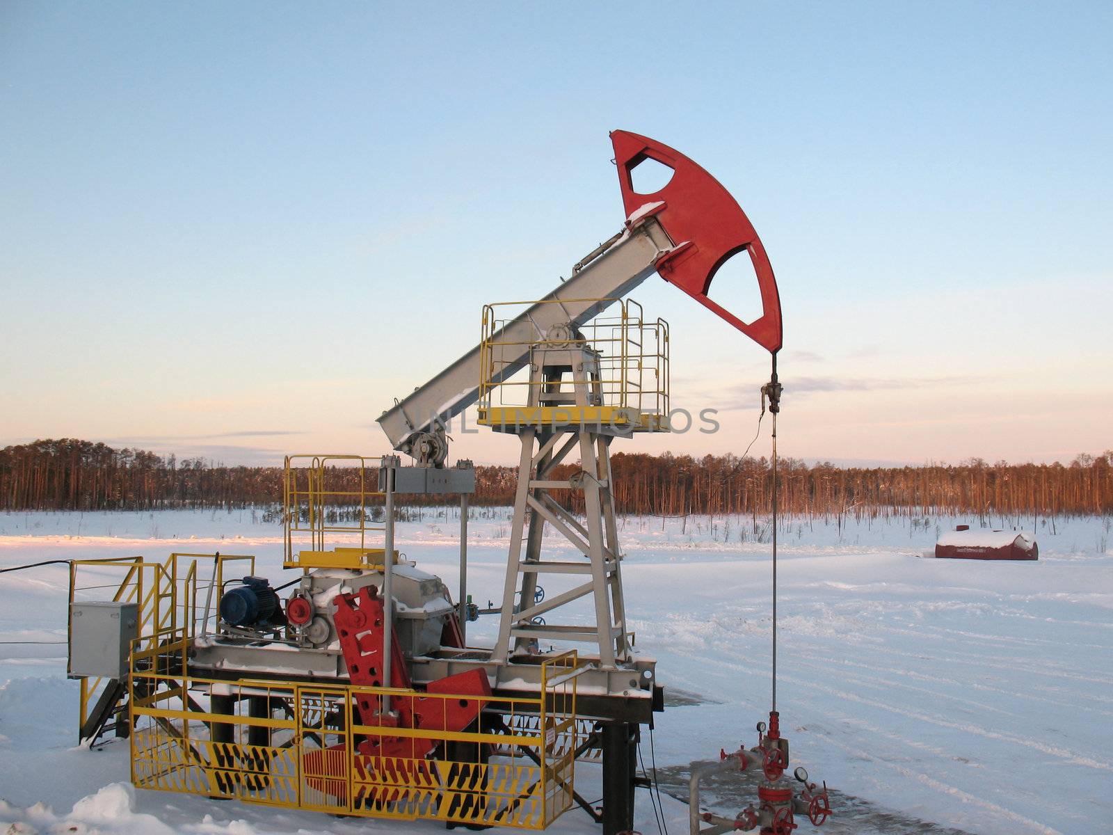 Oil pump jack in work. Oil industry in West Siberia. Siberian frost in sunny day.