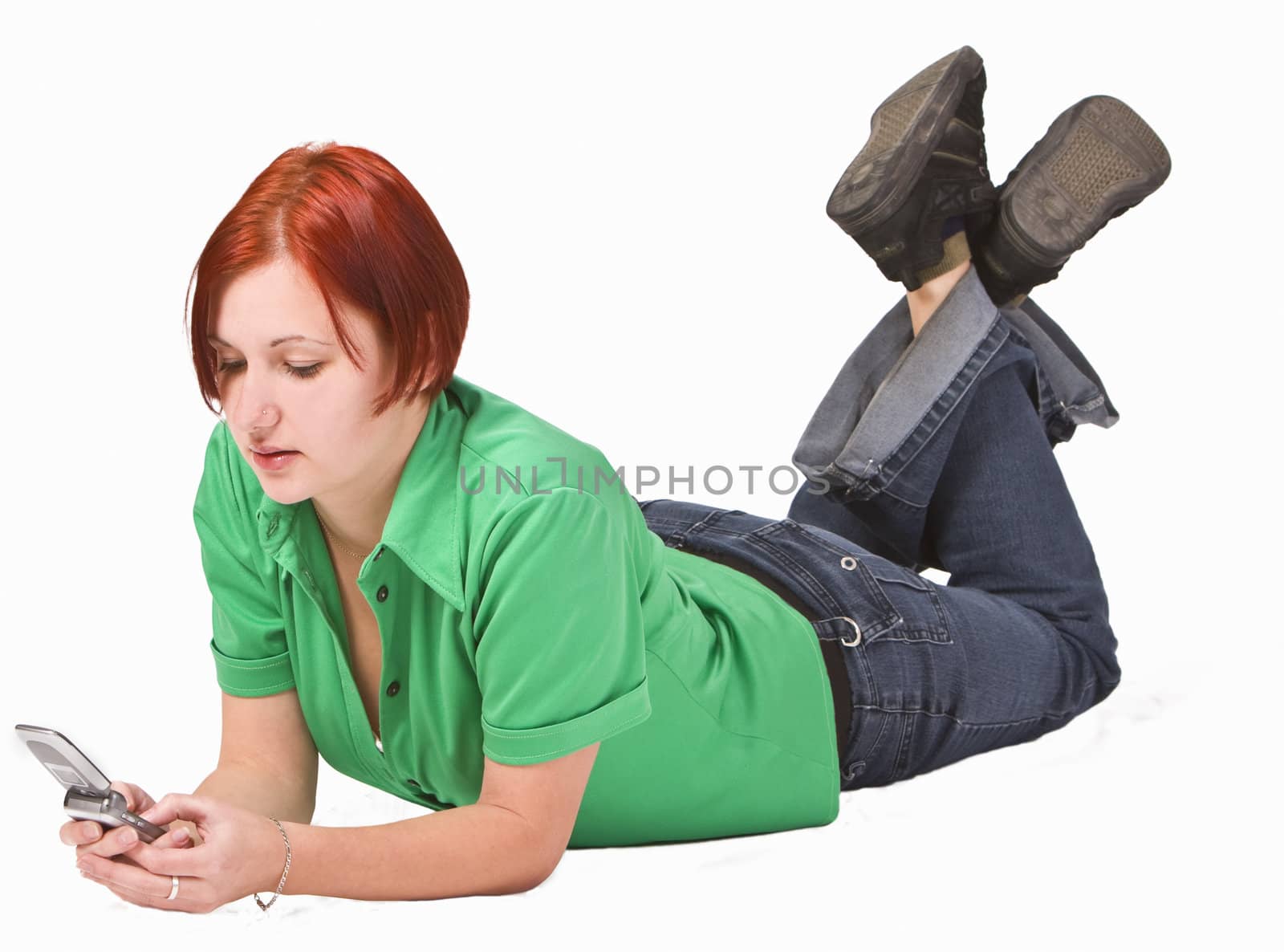 Redheaded teen girl lying down and using a mobile phone. 