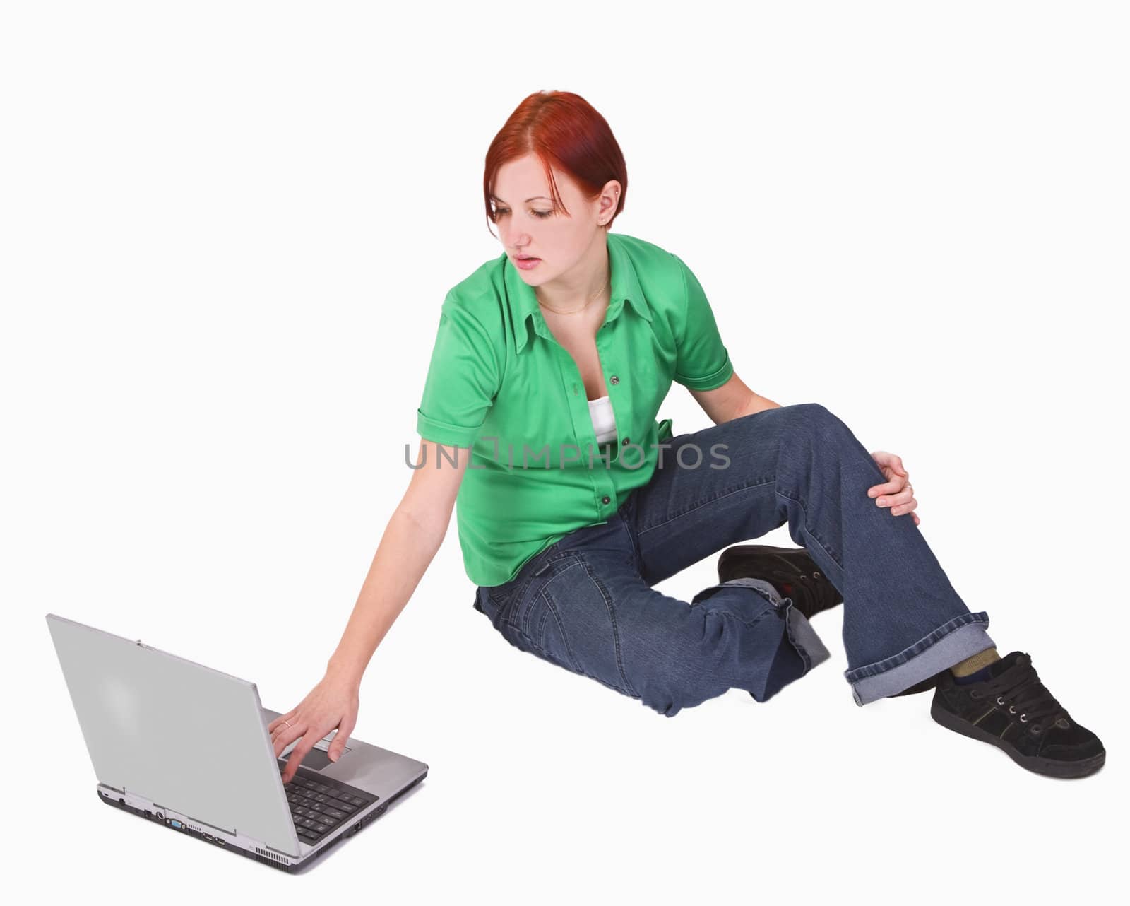 Redheaded teenager girl working on a laptop.