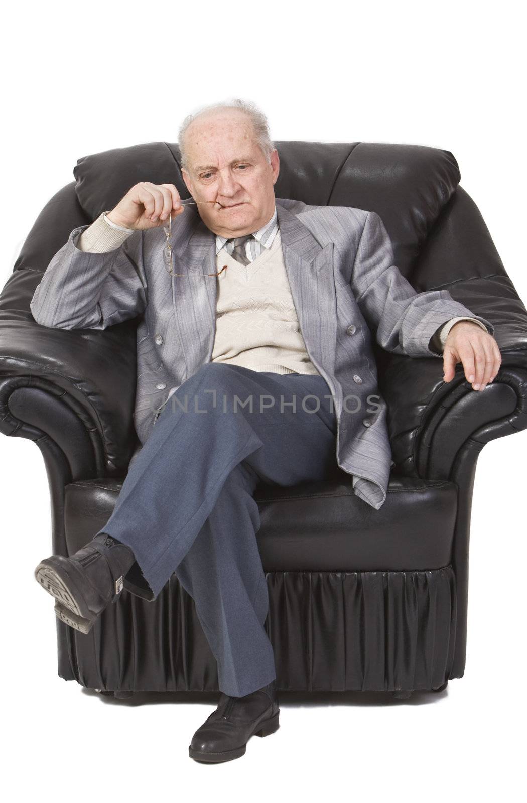 Portrait of a senior man sitting in an armchair and thinking deeply.Shot with Canon 70-200mm f/2.8L IS USM