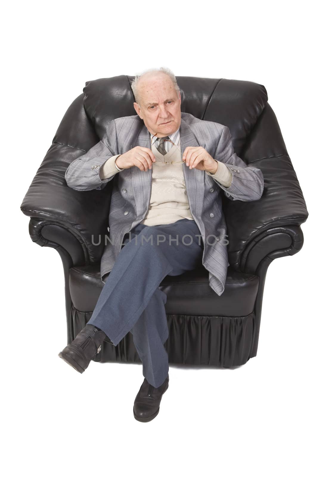 Senior man thinking and sitting in an armchair.Shot with Canon 70-200mm f/2.8L IS USM