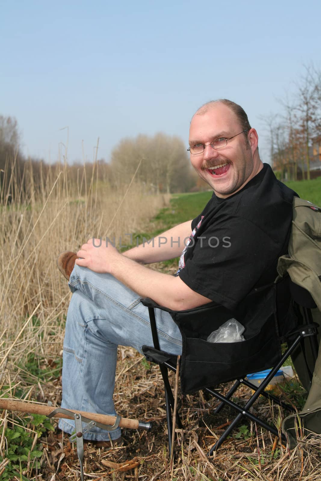 Happy fisherman by the side of the water