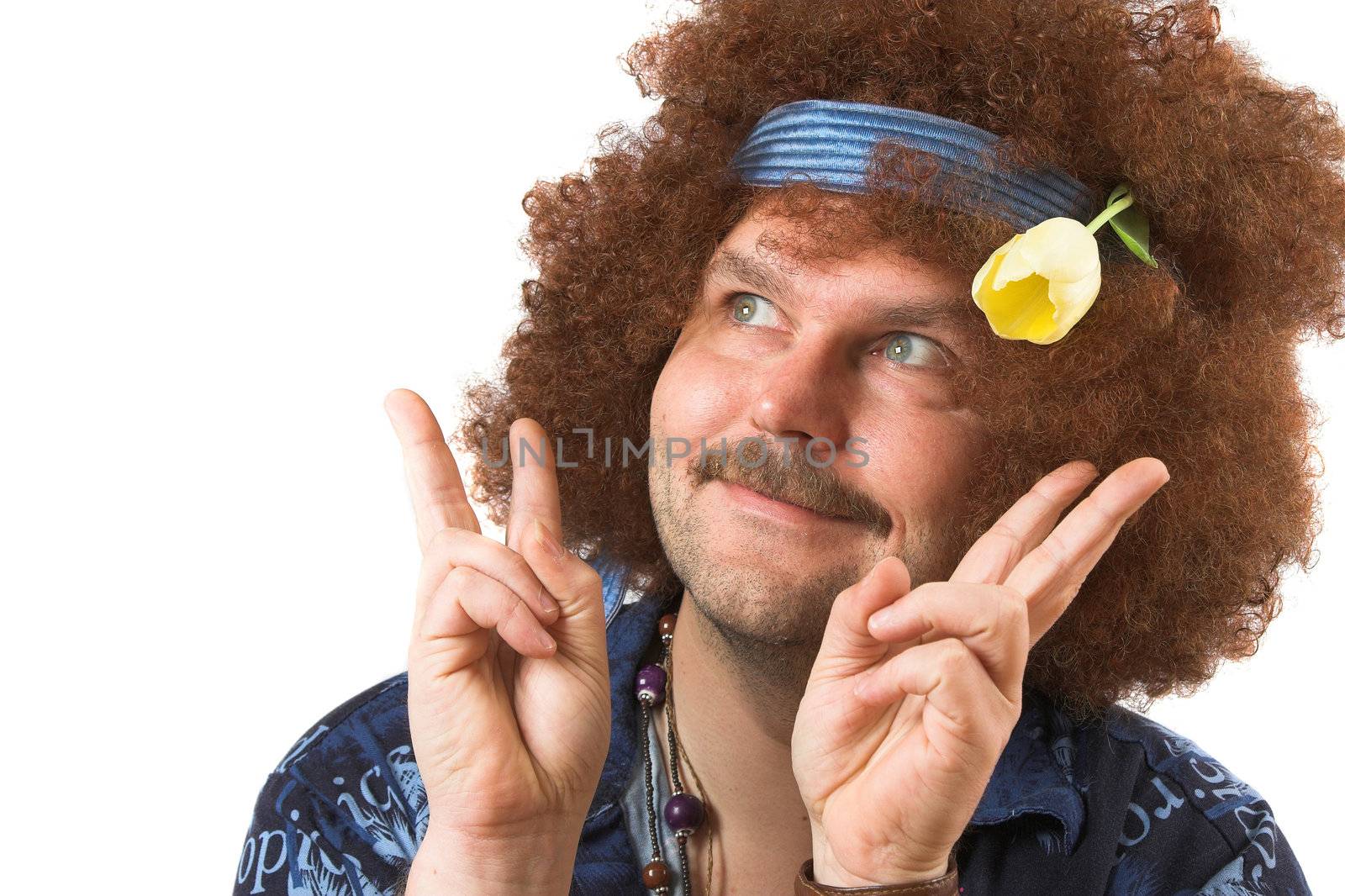 A slightly too old hippie making the peace sign with a tulip in his hair