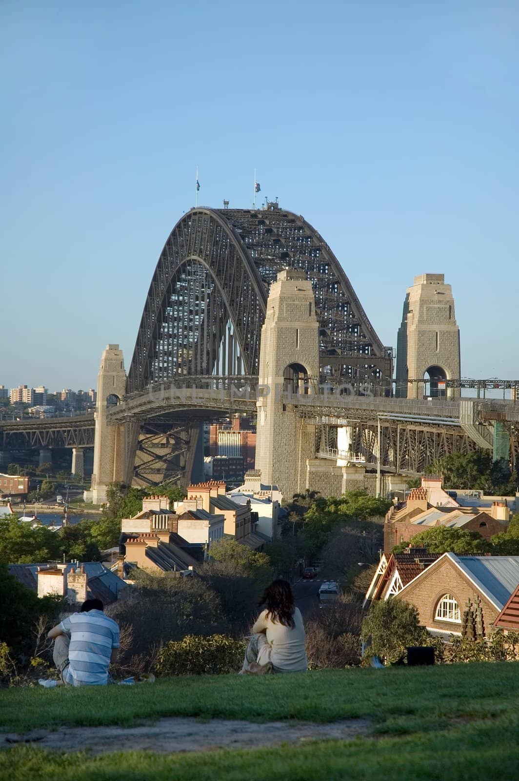 two people relaxing in park, Harbour Bridge in background, Sydney