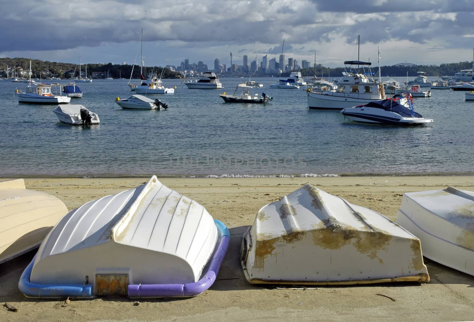 small boats on sand in foreground, motor boats in water, Sydney in distance, photo taken from Watson Bay