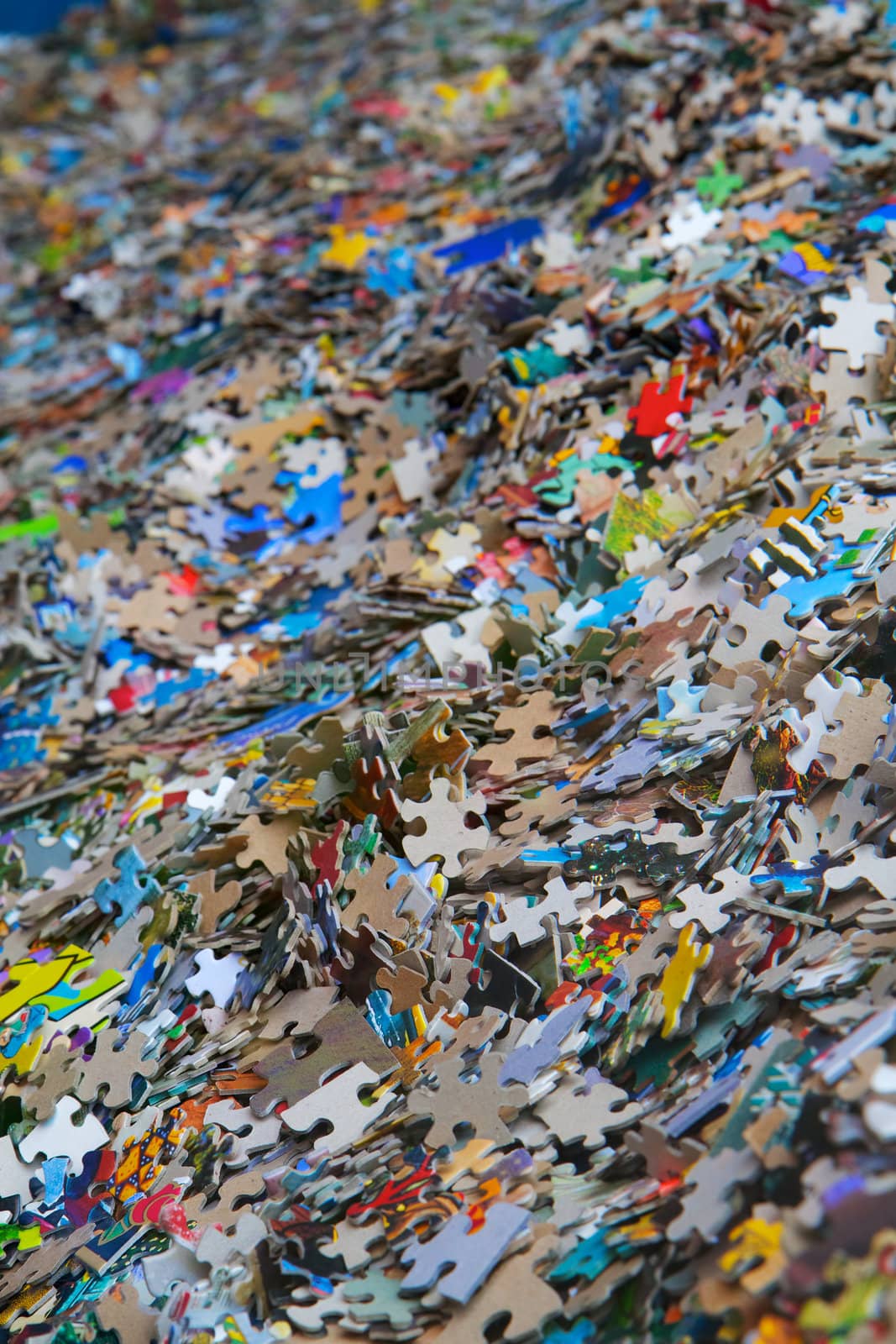 Piles of multi-colored jigsaw pieces that diminish to a soft focus background