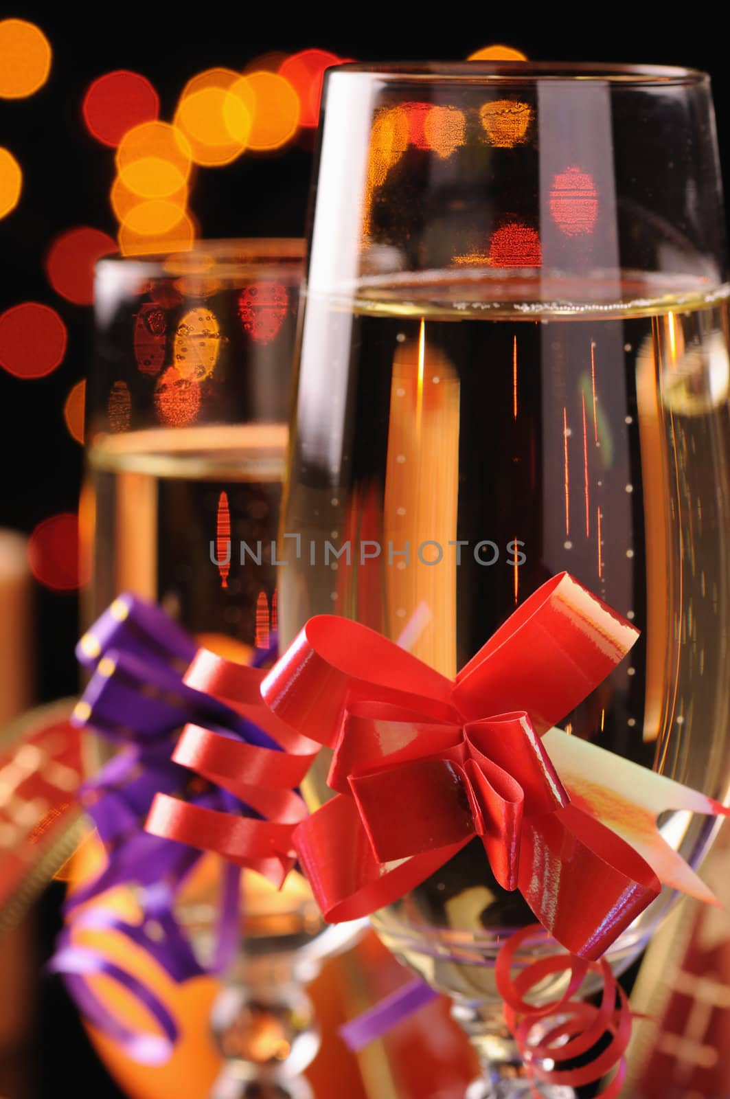 two wineglasses with a champagne on a background of multicoloured sparks