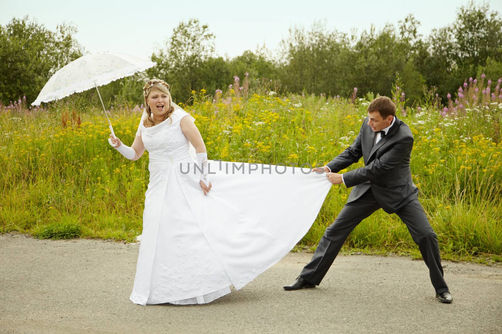 Funny bride and groom having fun outdoors