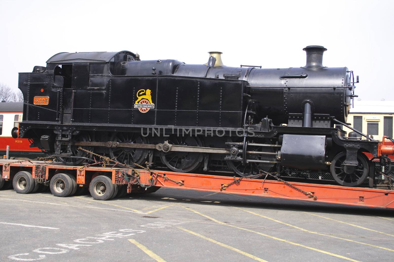 black steam locomotive on  a transporter by leafy