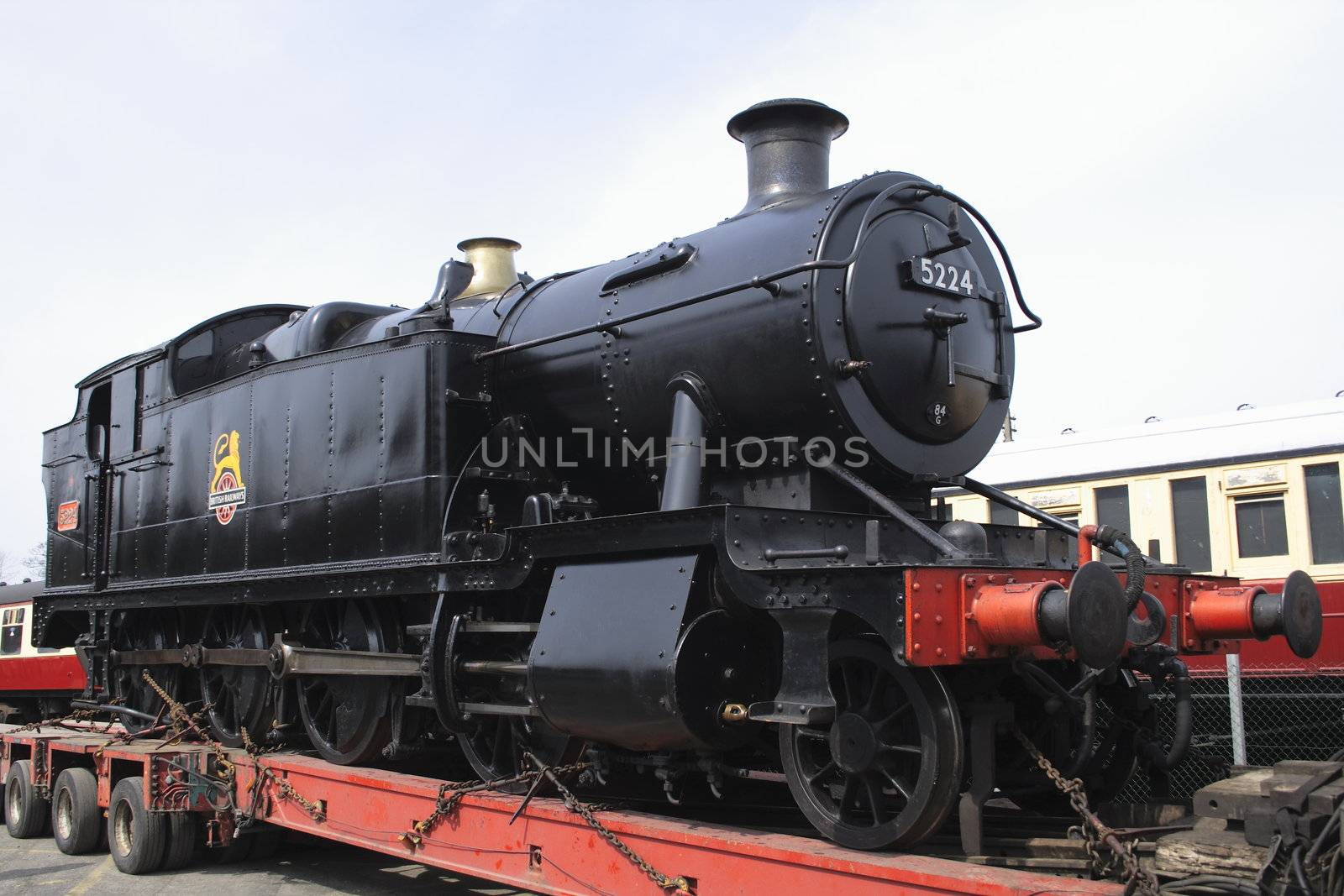 black steam locomotive on  a transporter by leafy