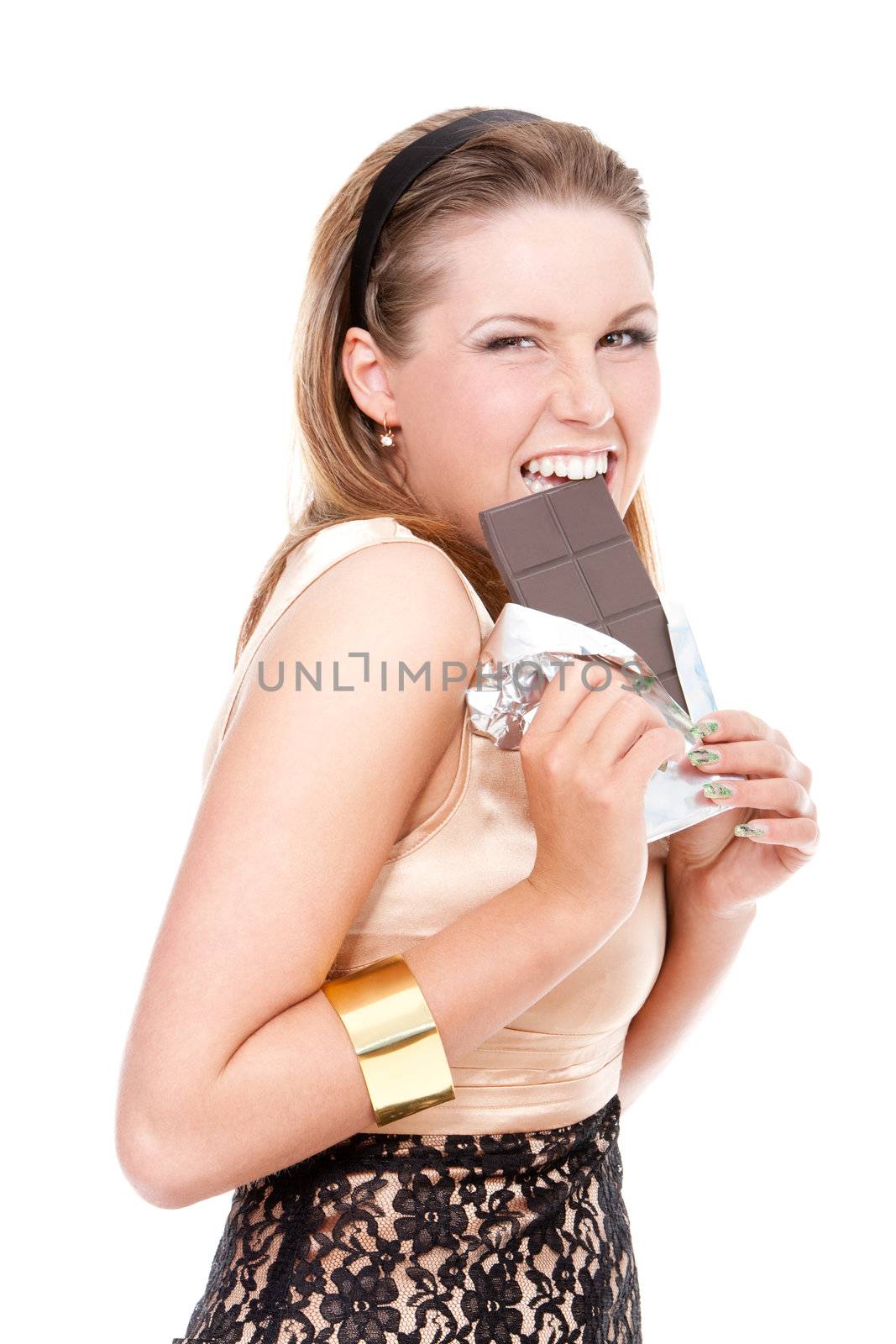 young girl biting a bar of dark chocolate on isolated white