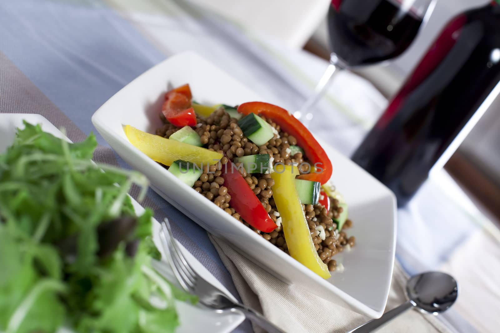 Fresh and healthy vegetarian lentil salad with red and yellow peppers.