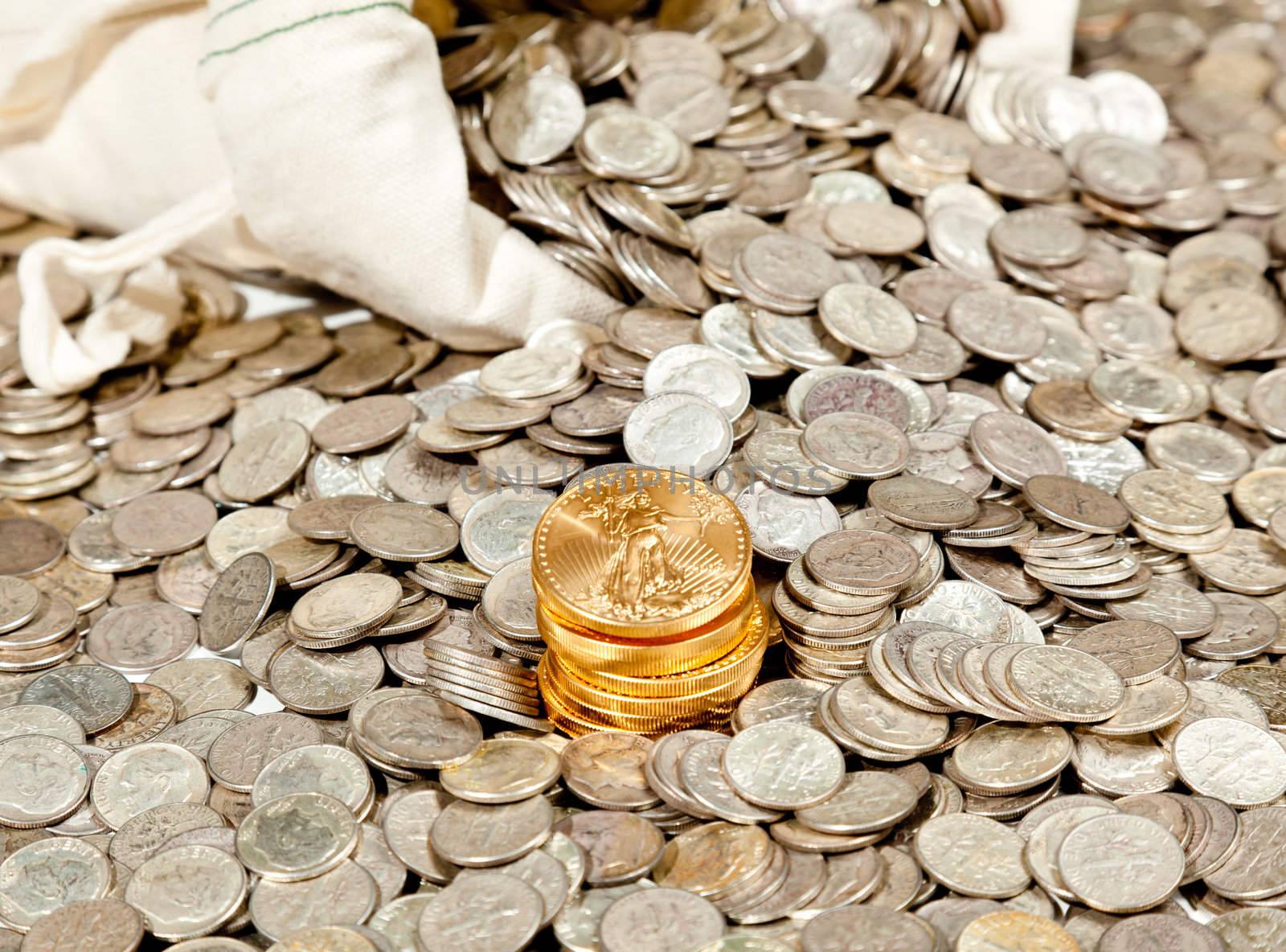 Linen bag of old pure silver coins used to invest in silver as a commodity with a selection of Golden Eagle gold coins