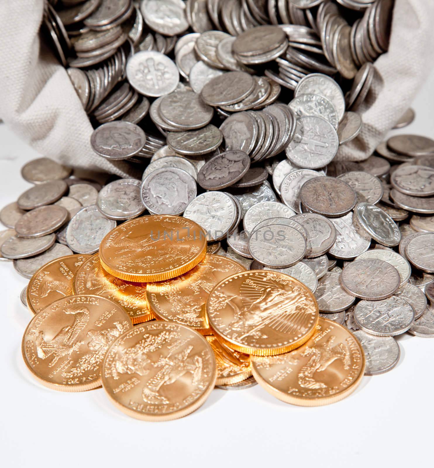 Linen bag of old pure silver coins used to invest in silver as a commodity with a selection of Golden Eagle gold coins