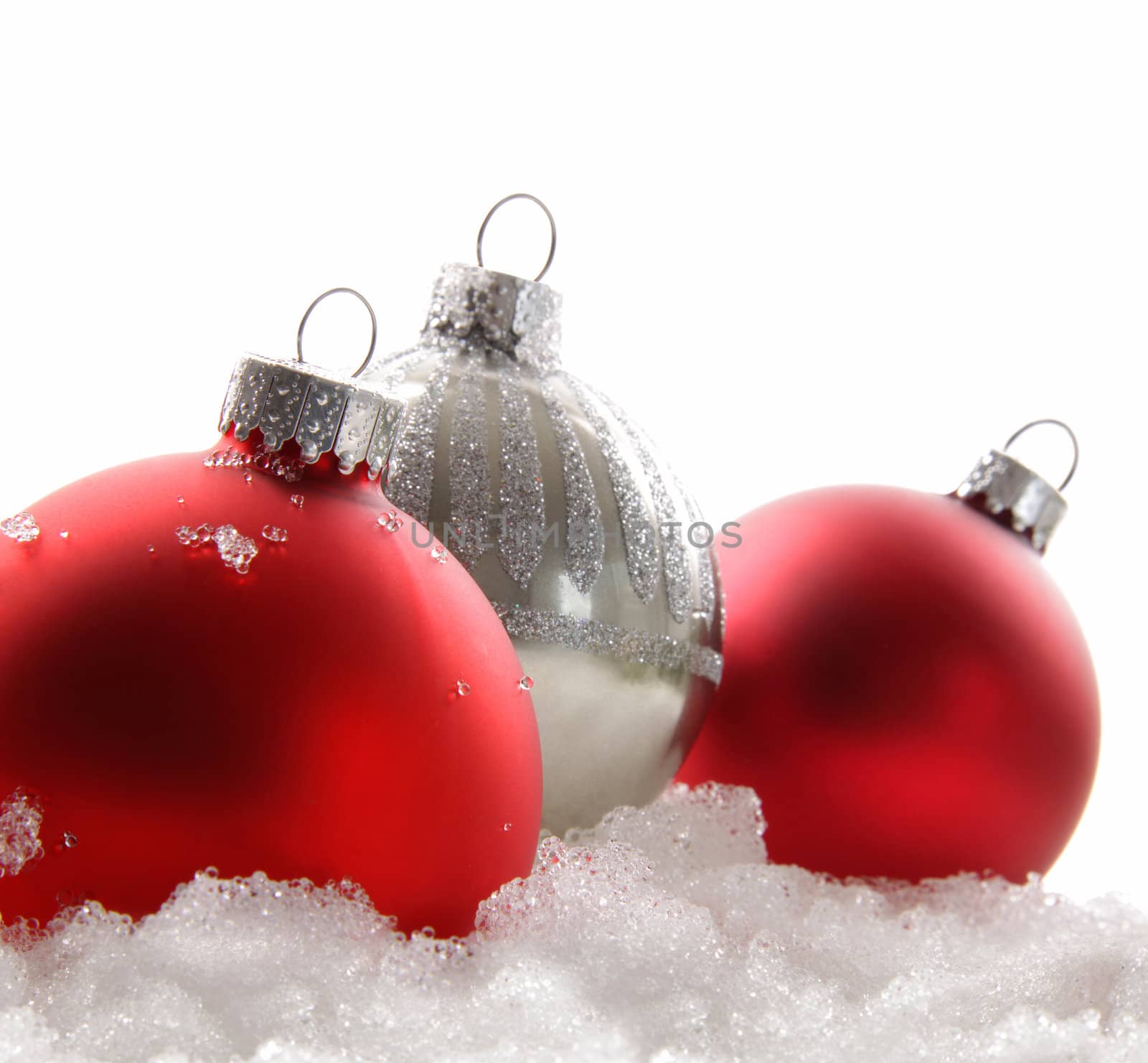 Three red christmas balls on white by Sandralise