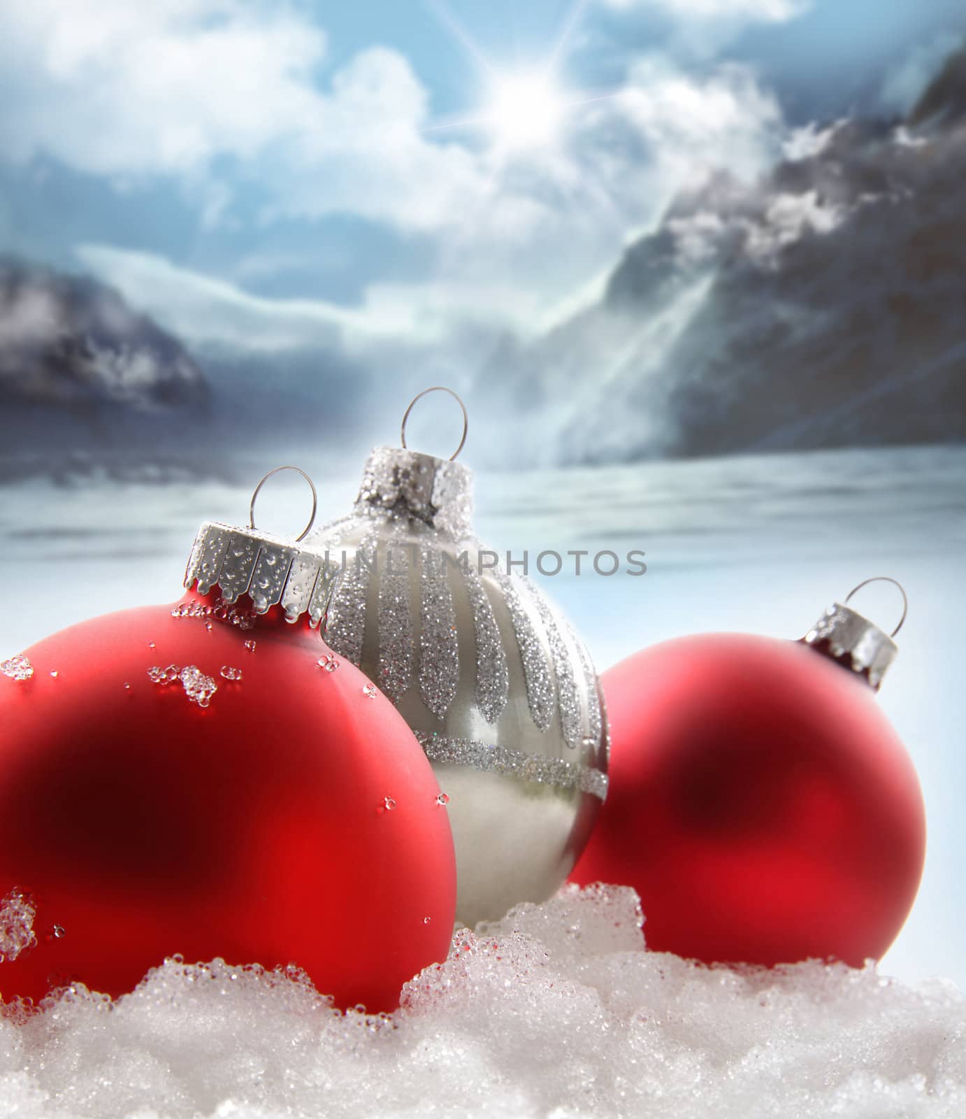 Three red christmas balls in the snow by Sandralise