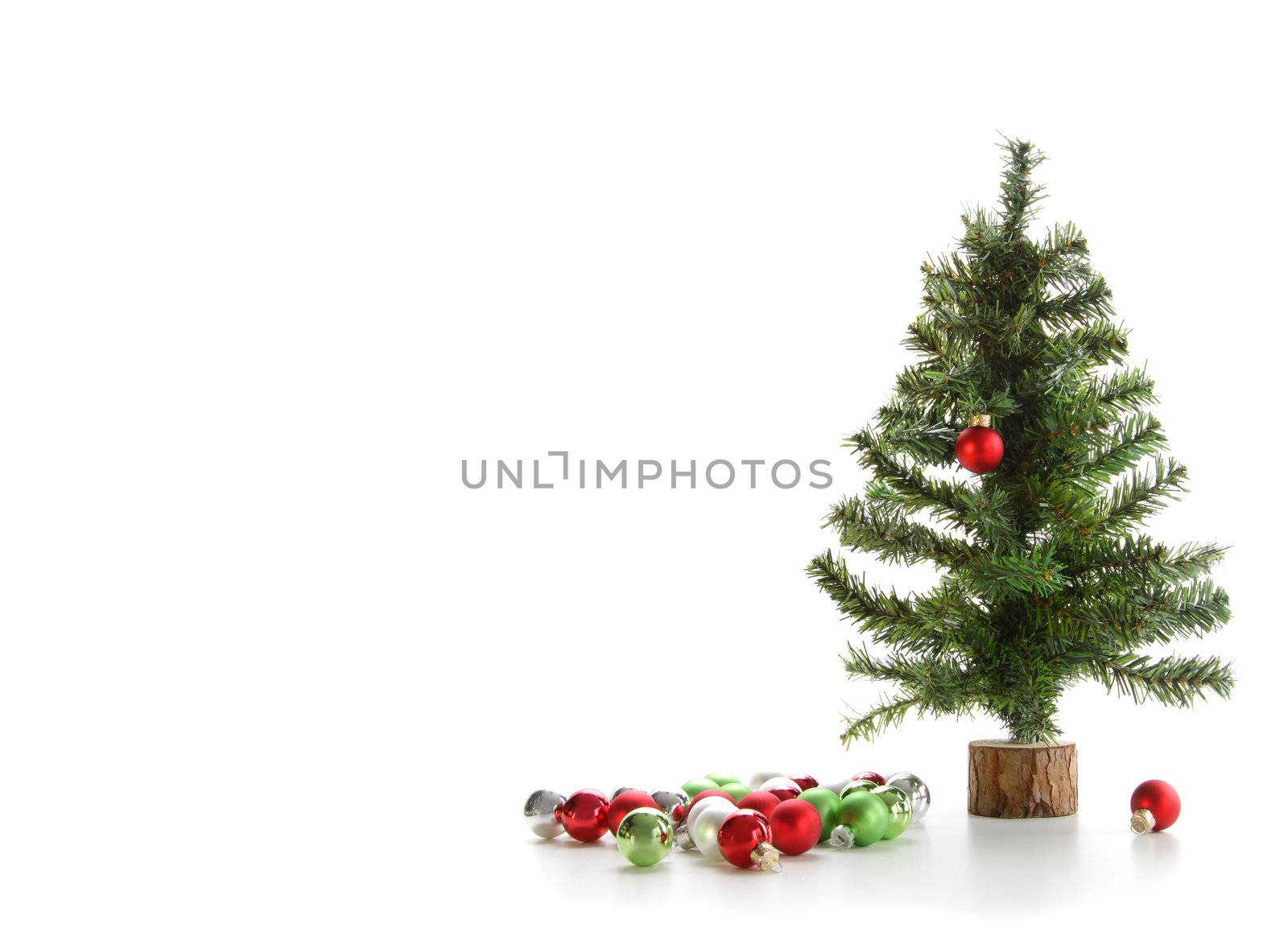 Small artifical tree with ornaments on white background