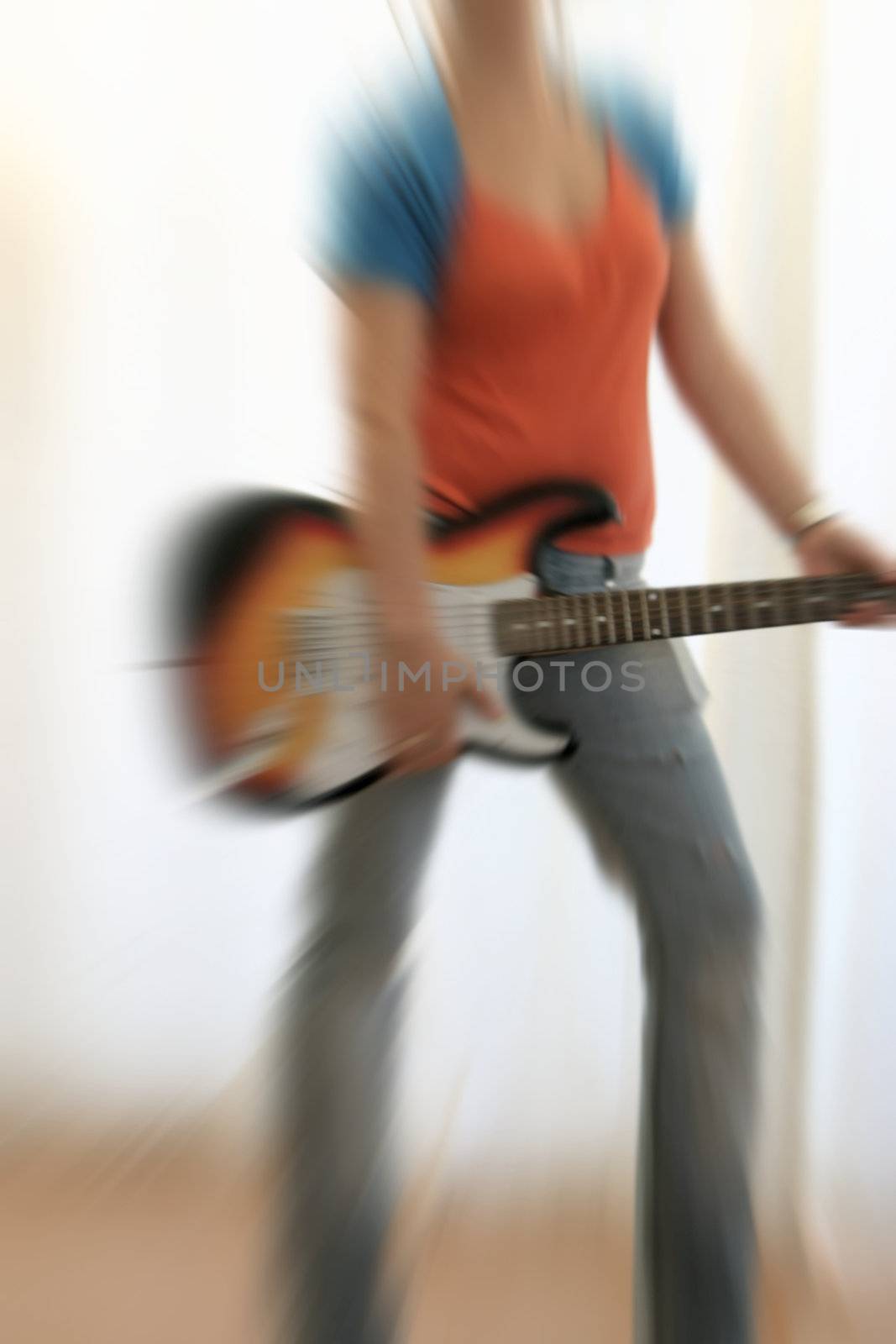 female guitarist playing electric guitar with radial blurr