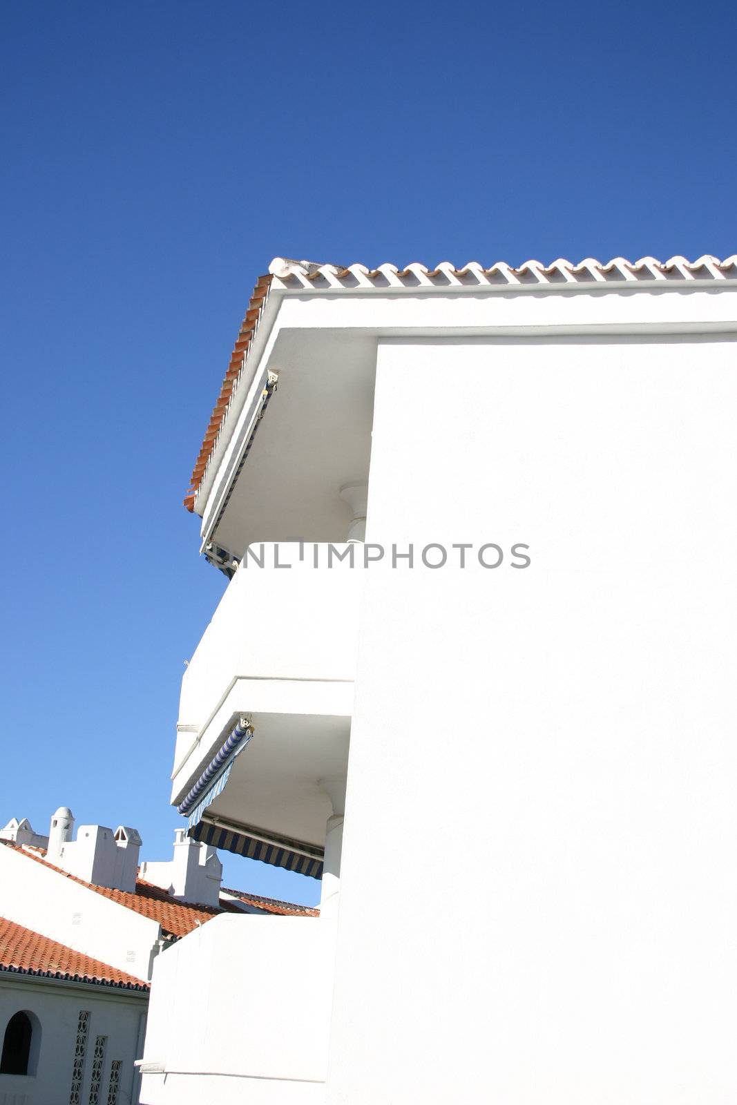 white washed apartment block against a blue sky