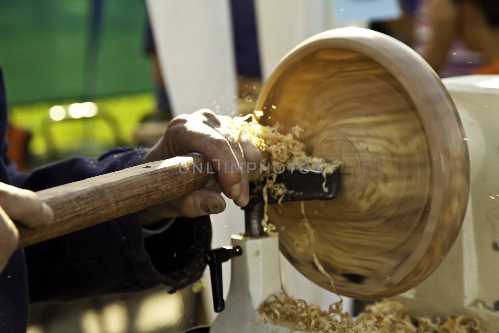 Craftsman's hands working with a lathe in a traditional way