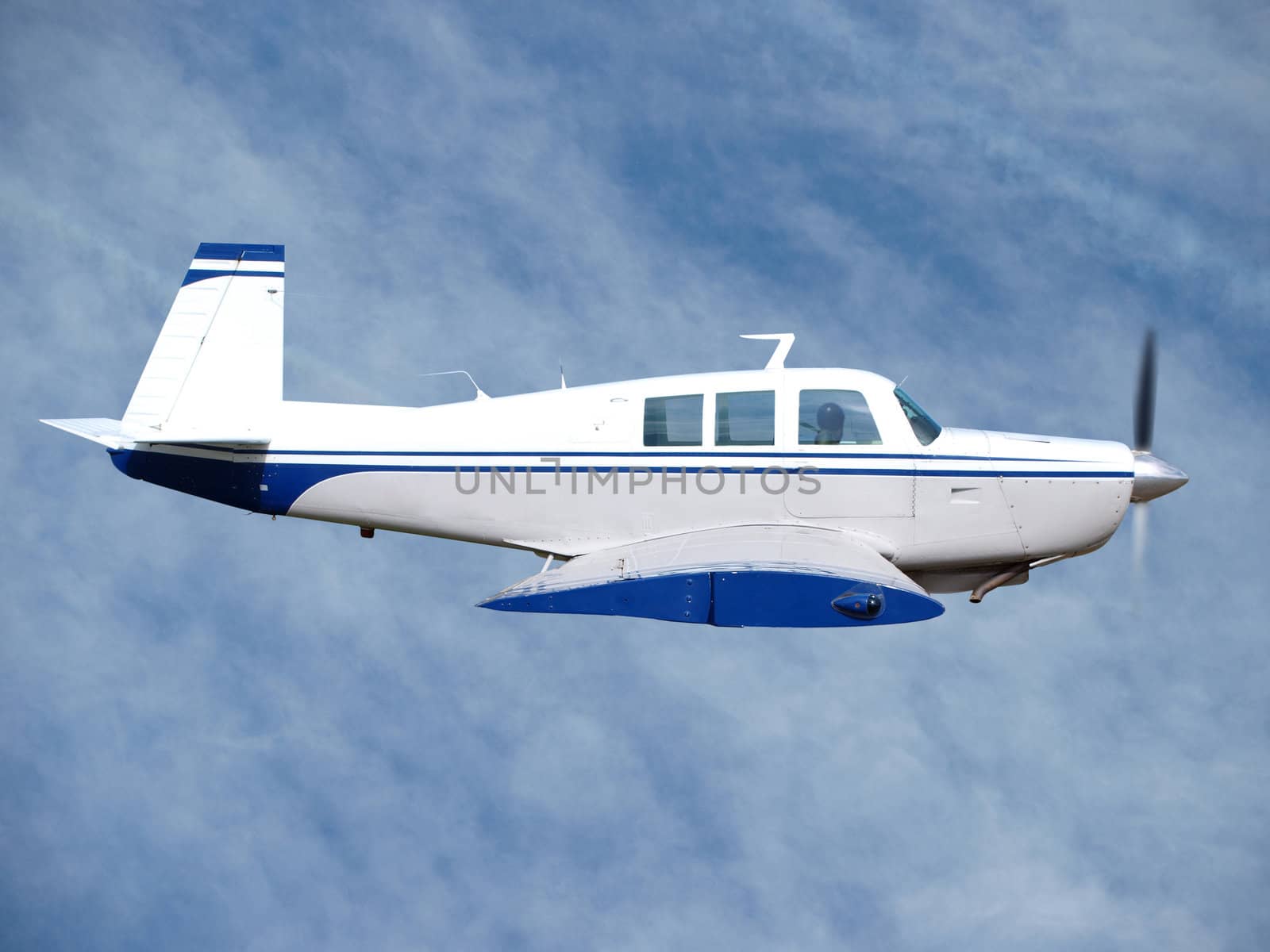 1980s private aircraft in flight against light cloud        