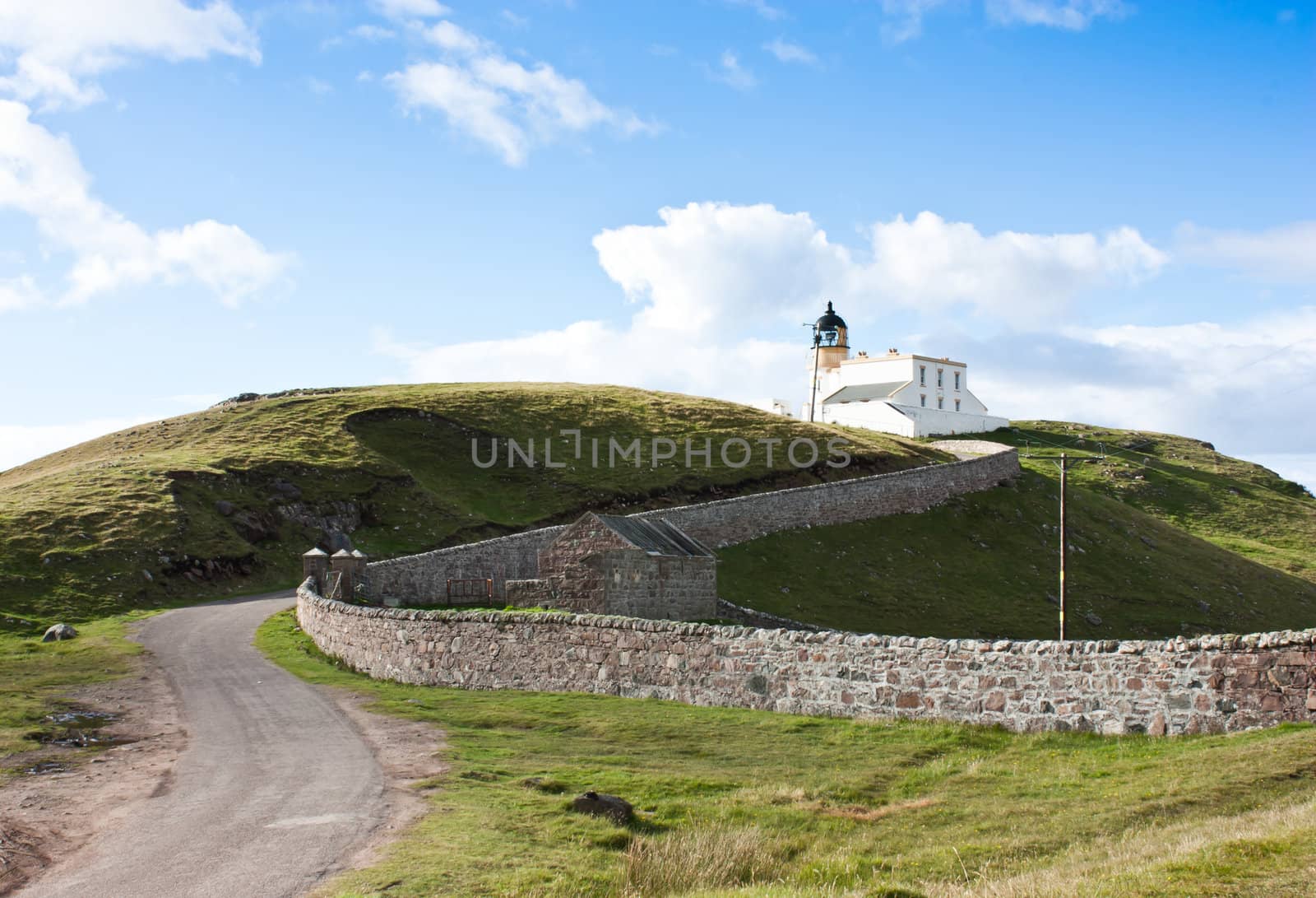 Tipical panorama of Scotland, with a lighthouse and blue sky