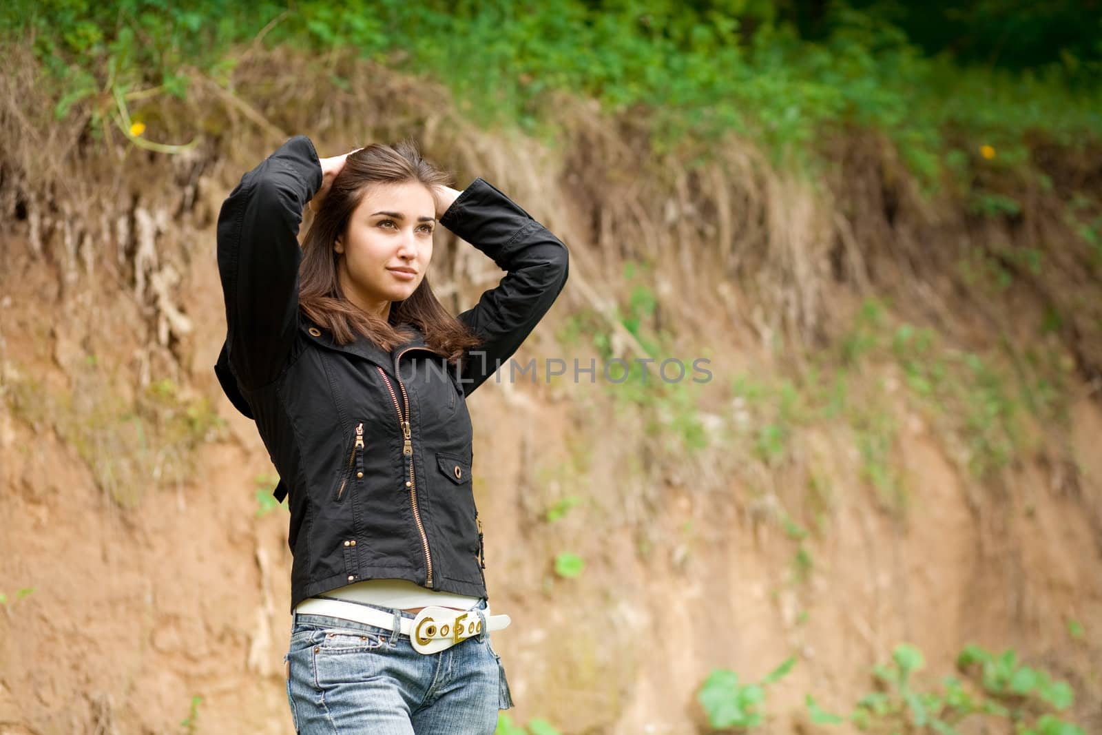 beautiful girl doing hair up and stay against the bluff