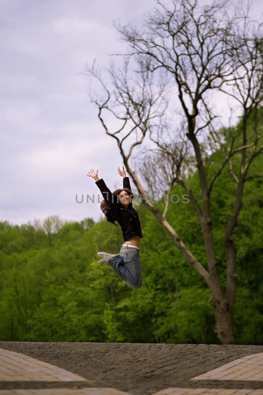 young girl jumping in park by lipik