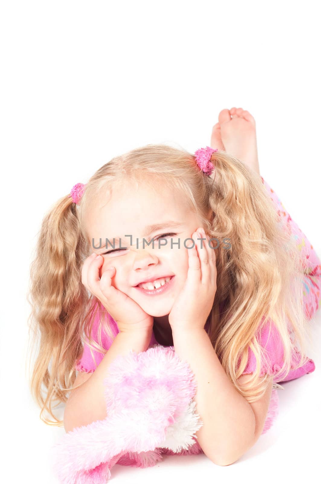 Little cute girl in pink and with ponytails in studio