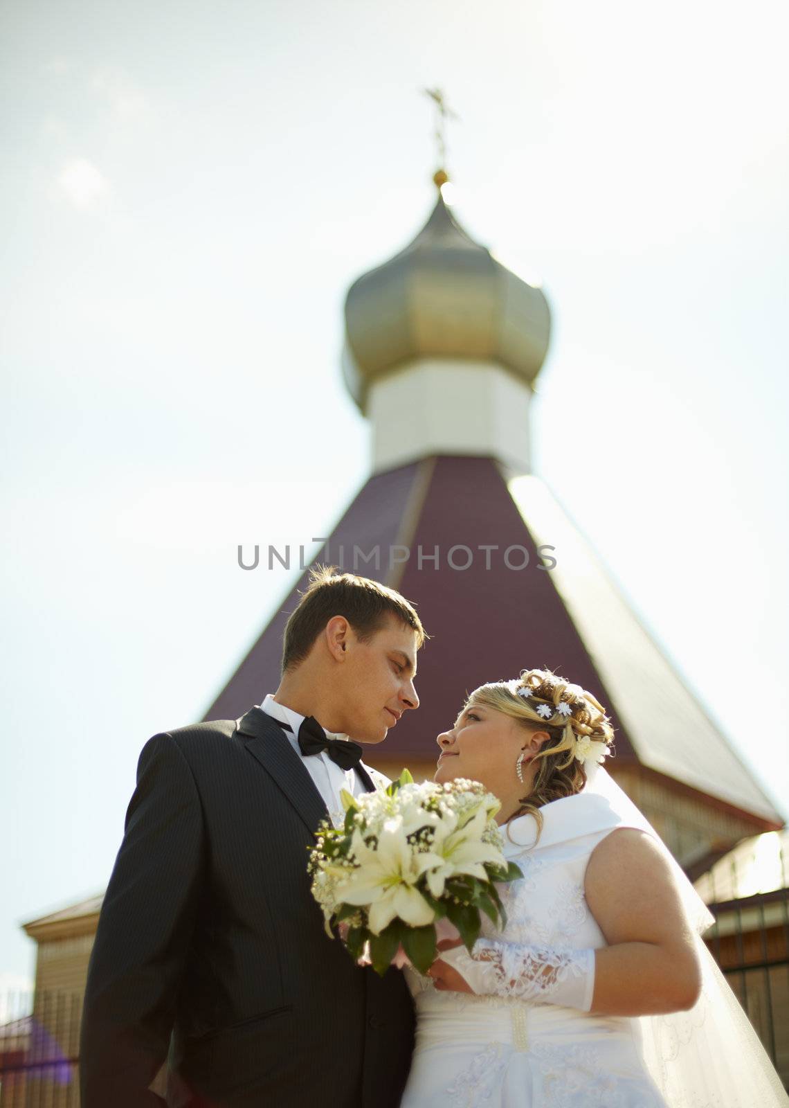 Bride and groom on background of Christian Church by pzaxe