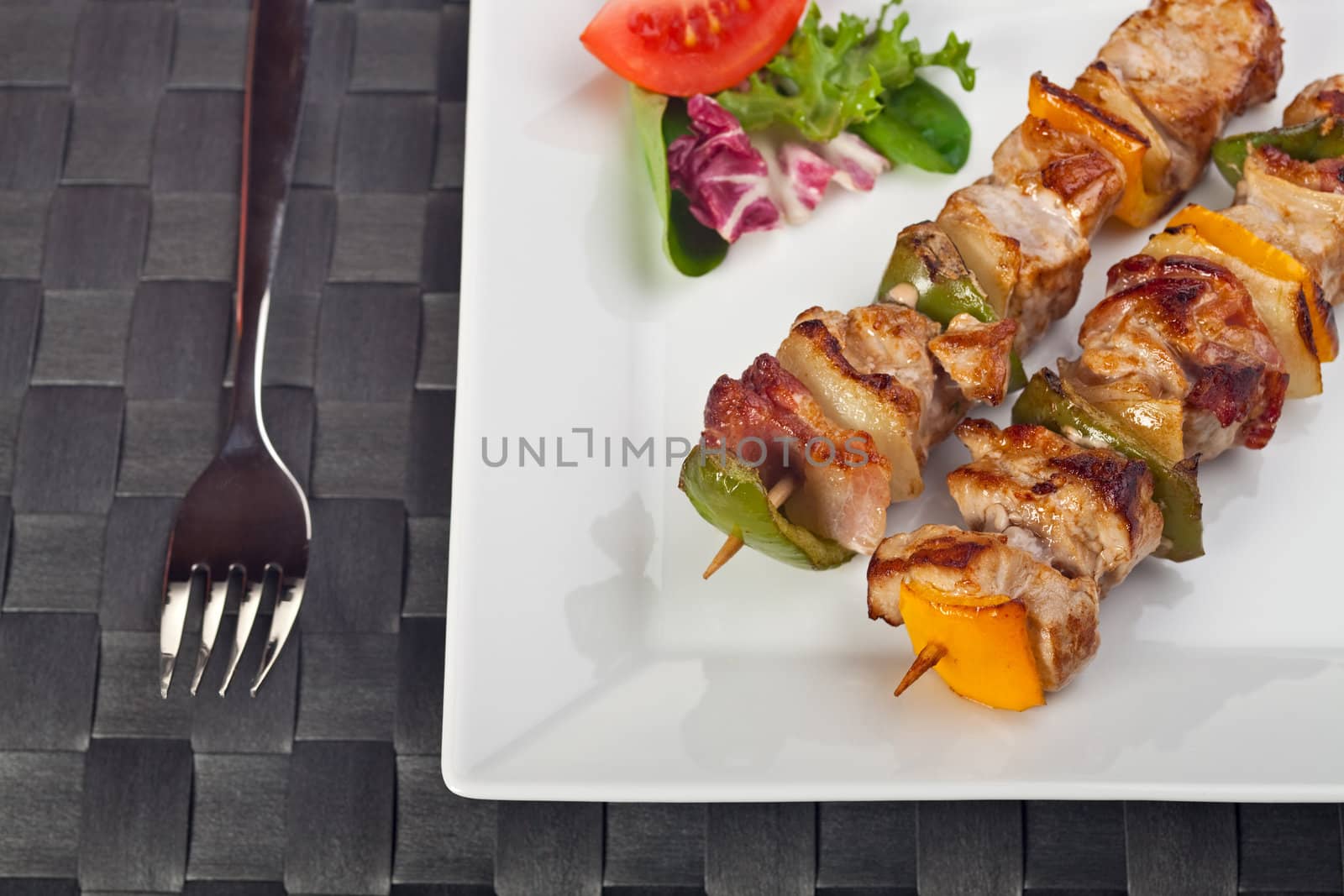 shashlik on a plate with a tomato and salad leaf by bernjuer