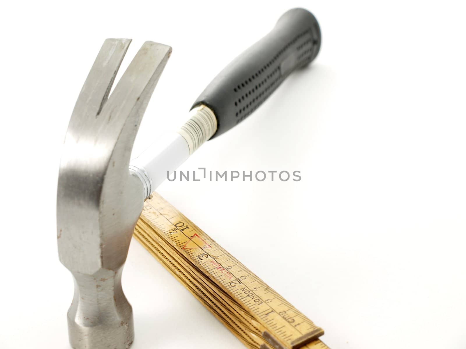 Hammer and wooden measurement tool, towards white background