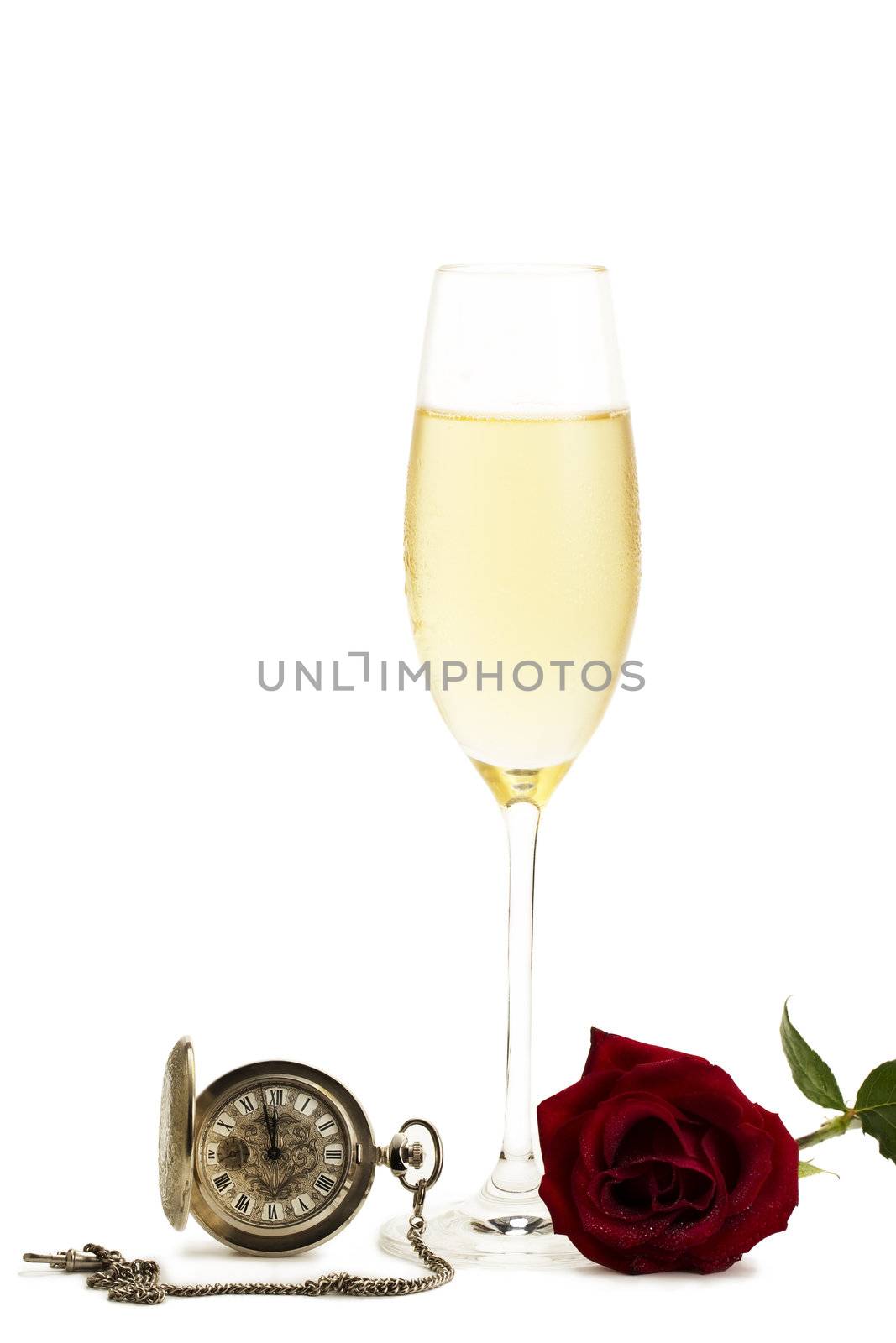 cold glass with champagne with a red rose and a old pocket watch on white background