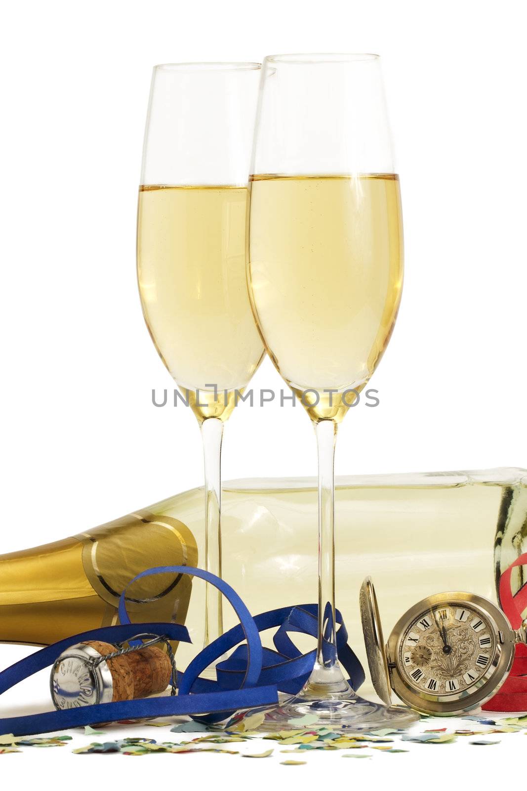 two glasses with champagne, old pocket watch, streamer, cork and confetti in front of a champagne bottle on white background