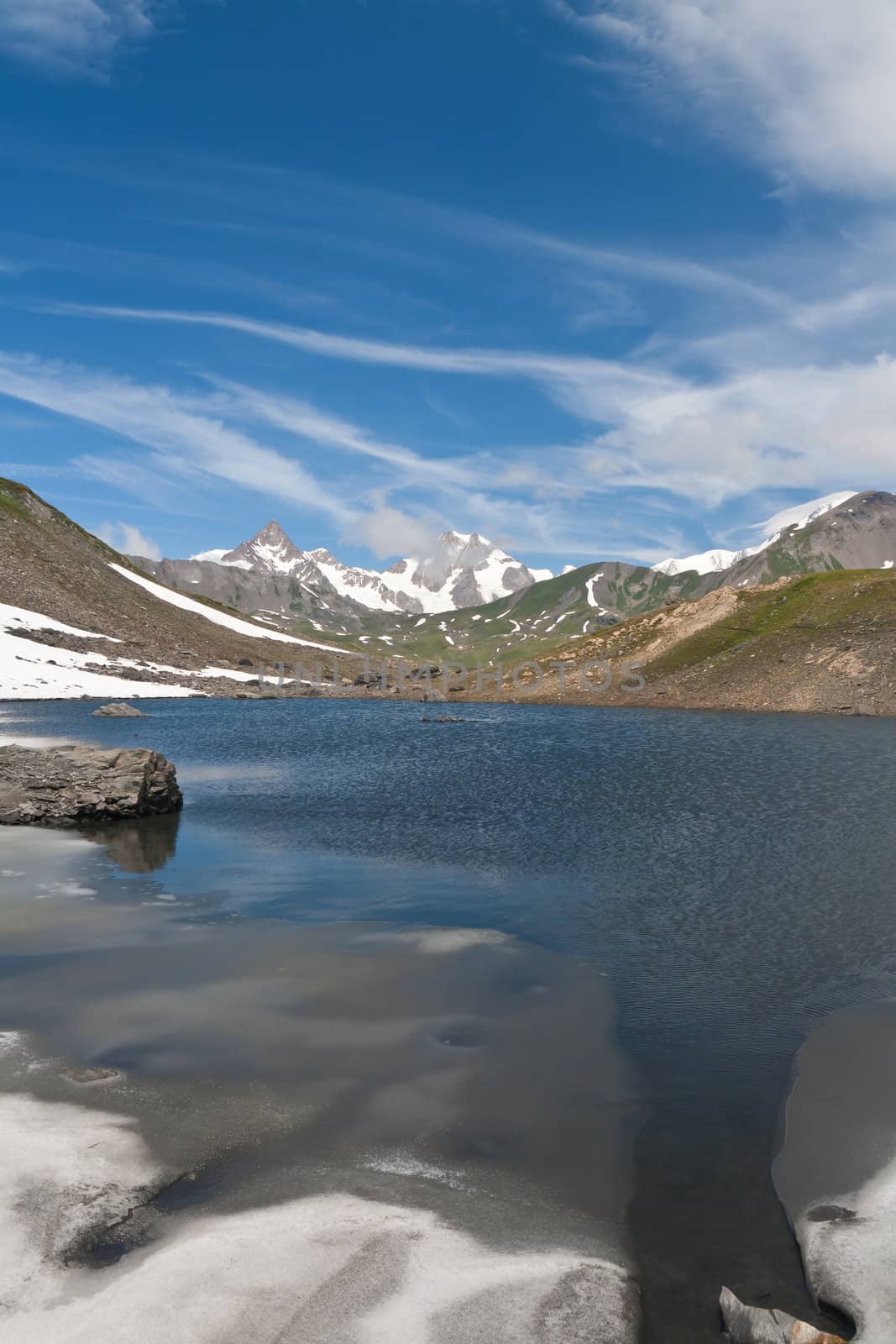 small lake in  Pointe Rousse pass, Aosta valley, Italy with Mont Blanc massif on background
