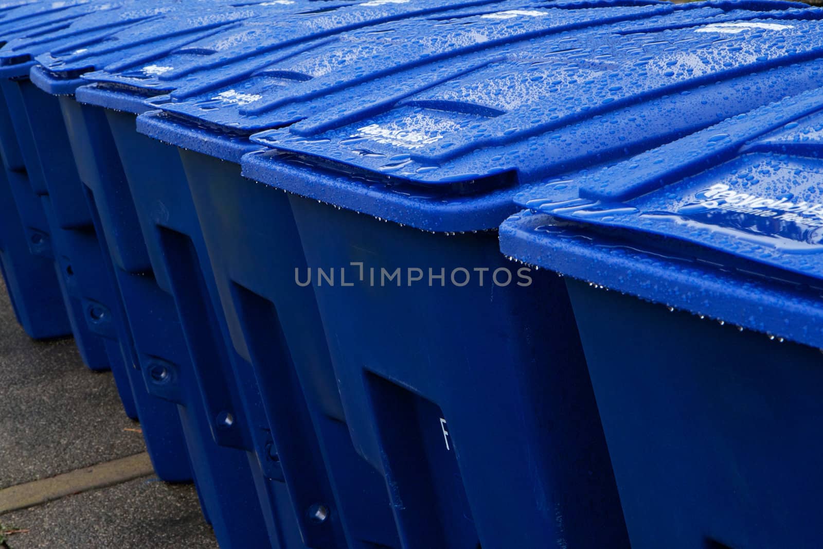 Close up of wet blue large recyling bins