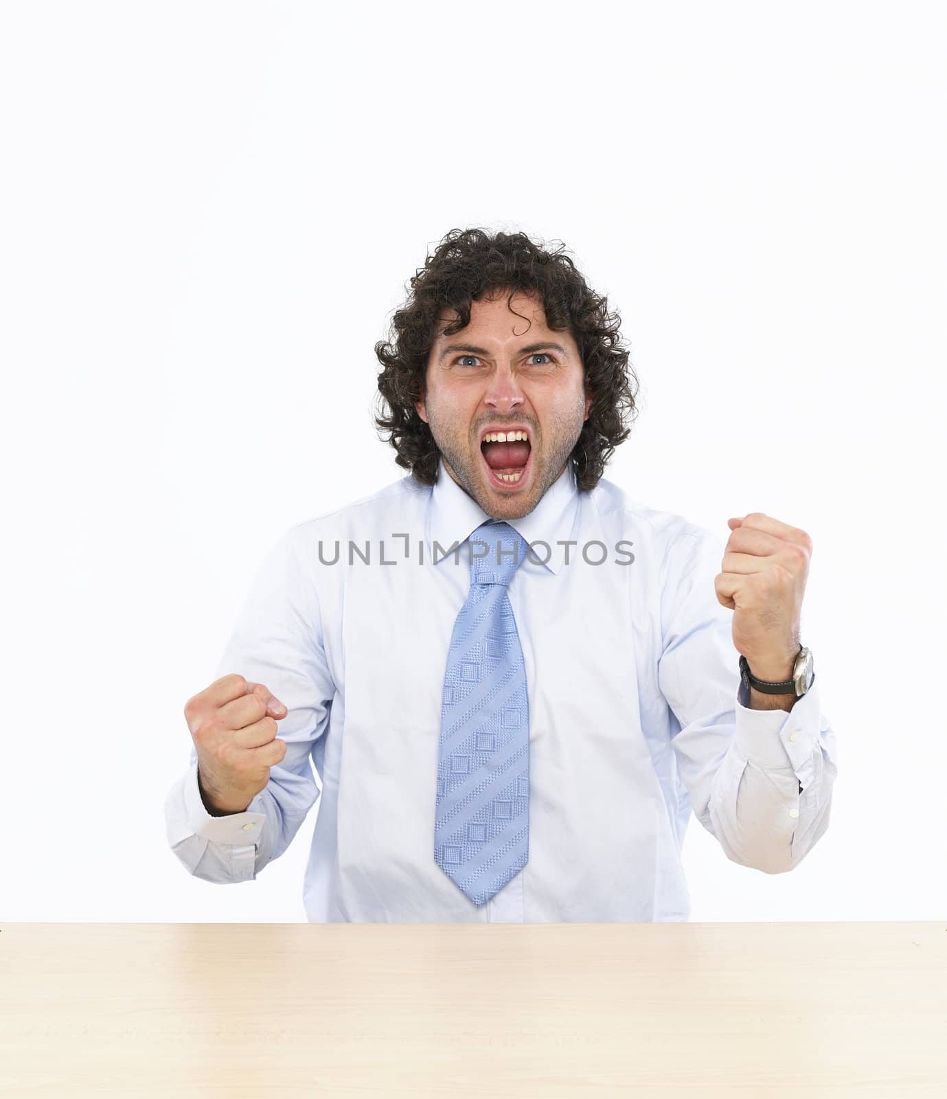 Happy businessman raising his arms sitting at his desk isolated on white background