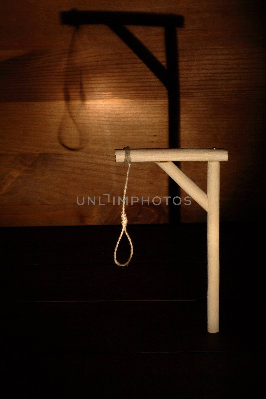 Gibbet with loop on gloomy wooden background